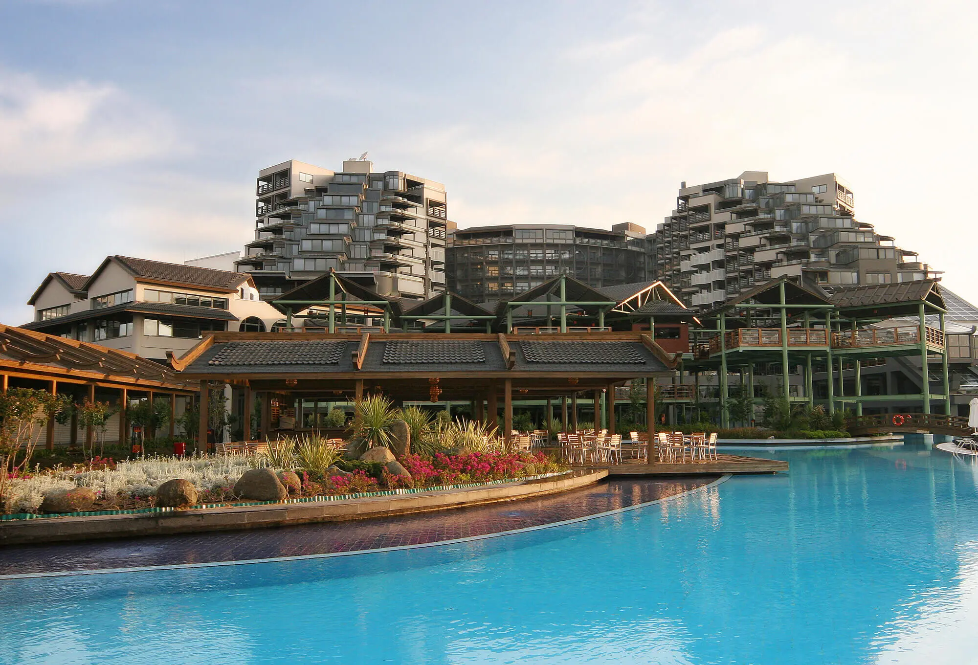 Басейн с кристално синя вода пред терасите и сградите на хотела – Limak Lara DeLuxe Hotel & Resort, Лара Кунду