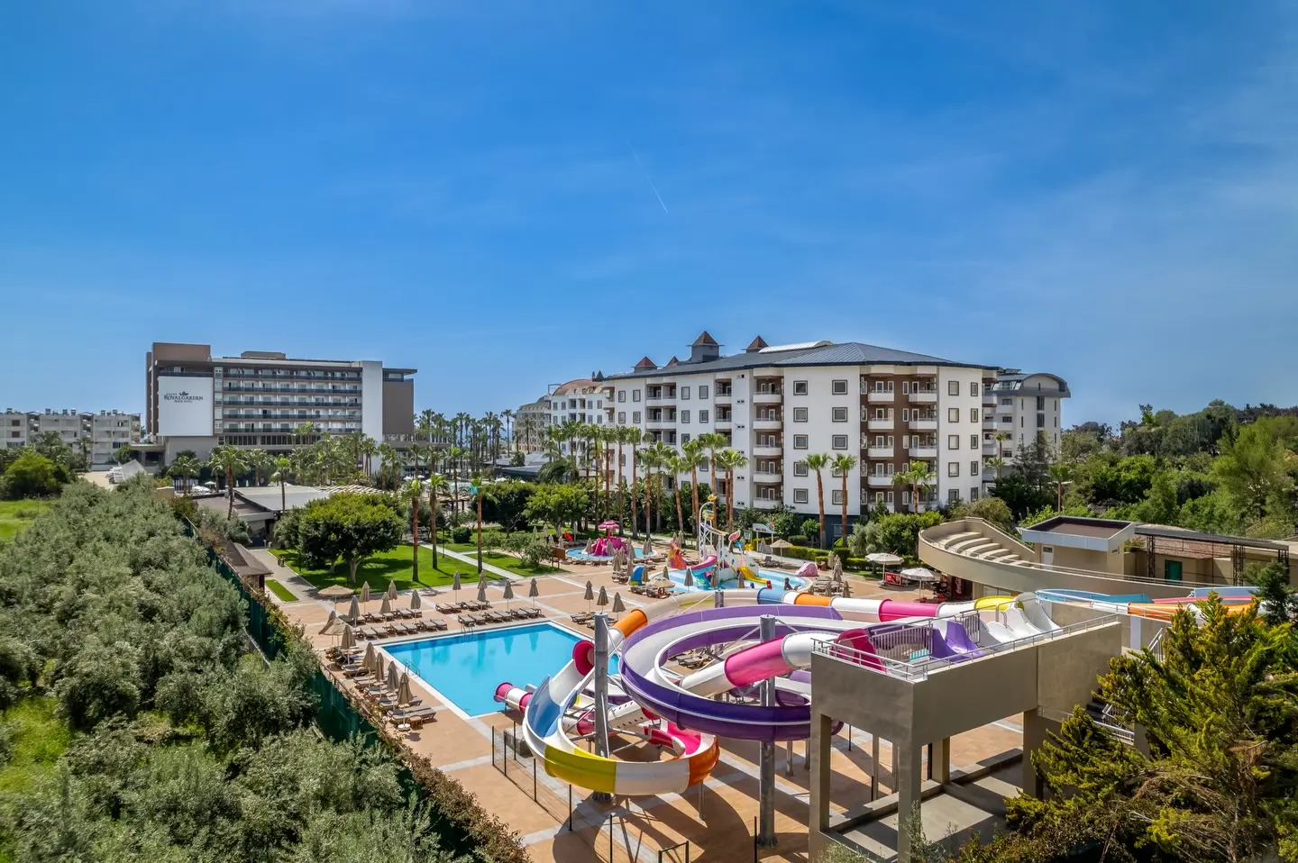 Аквапарк с цветни детски пързалки и хотелските сгради на фона – Royal Garden Beach Hotel, Алания