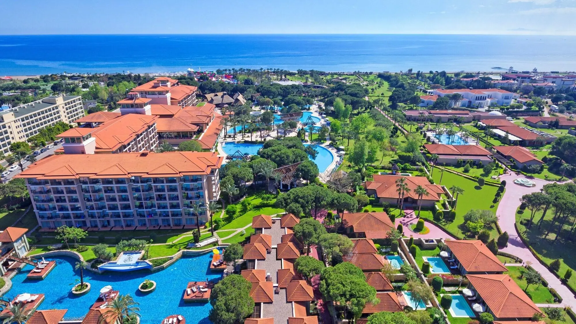 Въздушен изглед към хотела с басейни и зелена градина край морето – IC Hotels Green Palace, Лара
