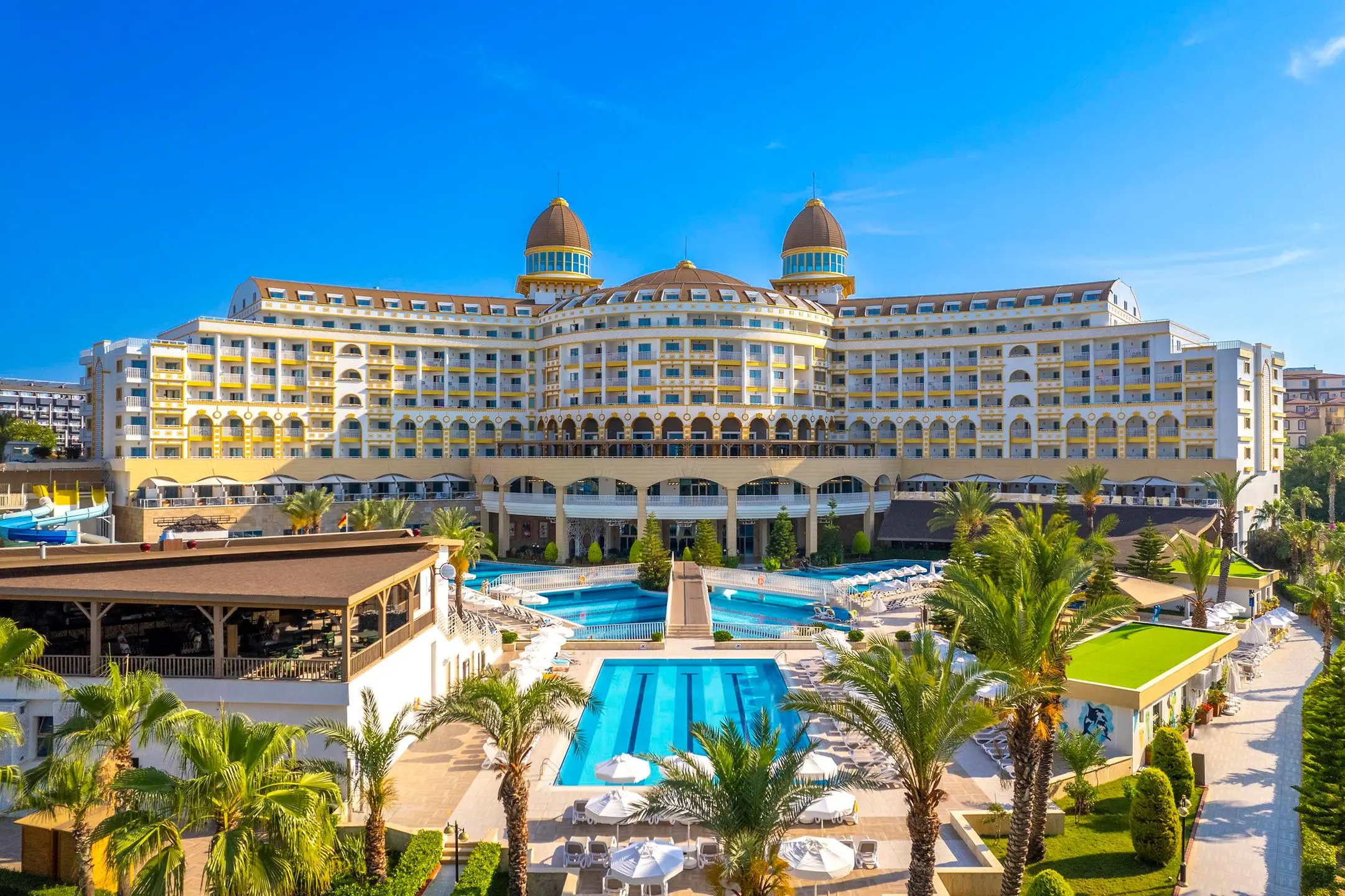 Фасадата на хотела с палми и басейн отпред – Kirman Sidemarin Beach & Spa, Сиде