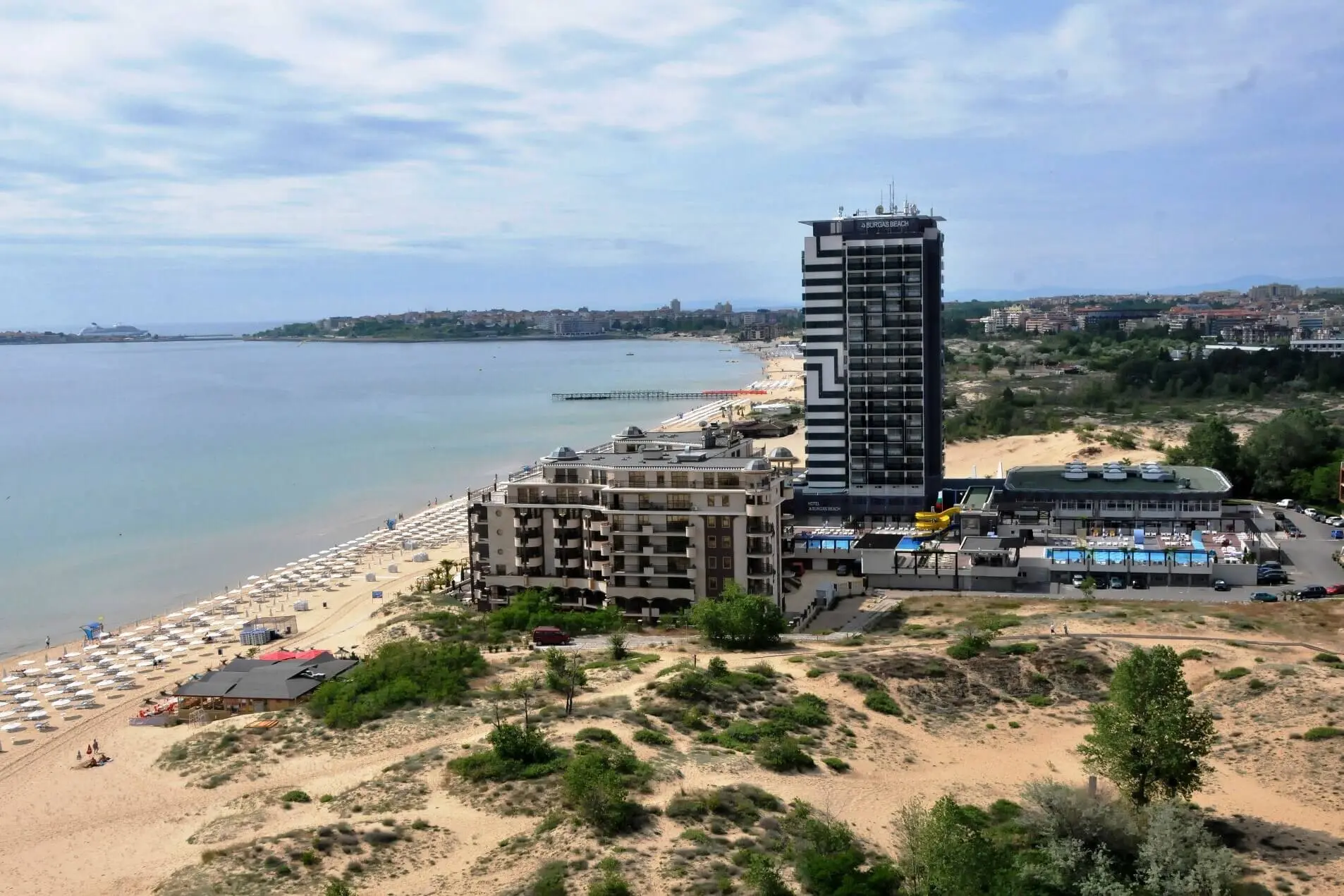 Високата сграда на хотела сред пясъчните дюни до плажа, с изглед към залива – Бургас Бийч, Слънчев бряг