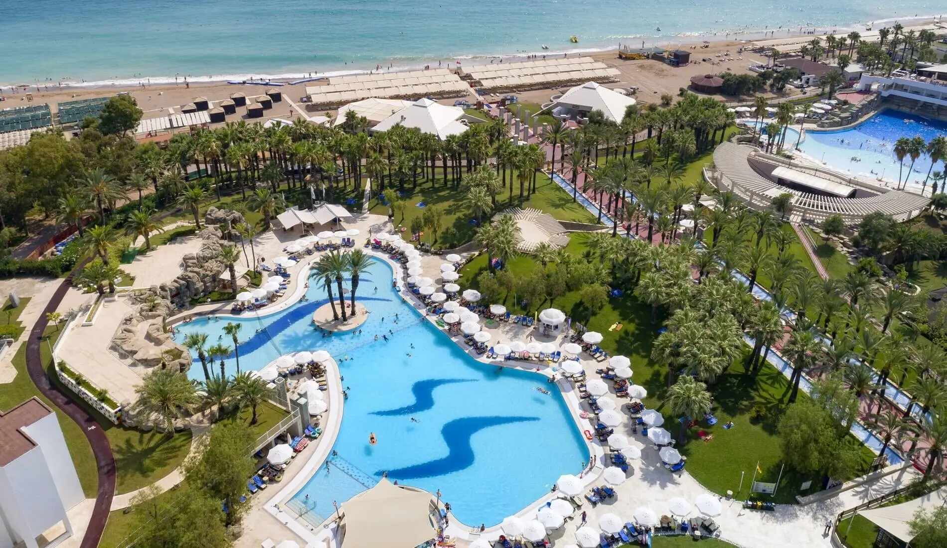 Басейн с вълнообразна форма сред палми и плажна ивица до морето – Monachus Family Resort Sorgun, Сиде
