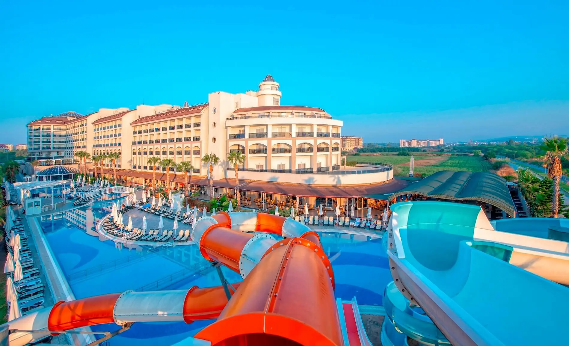 Басейн с червена и оранжева водна пързалка пред хотелския корпус – LRS Port River Hotel & Spa, Сиде