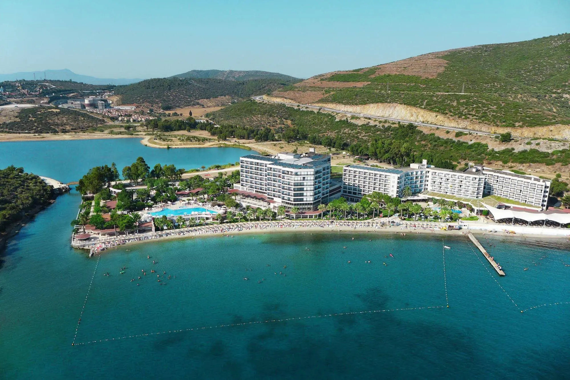 Панорама към хотела на нос с басейн, плаж и залив с тюркоазено море – Tusan Beach Resort Hotel, Кушадасъ