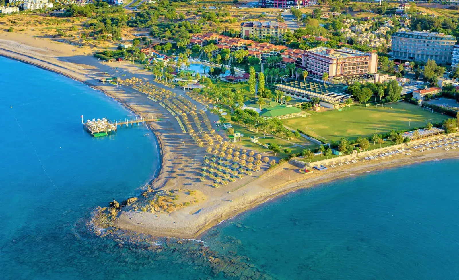 Въздушна снимка на плажа с кей и хотела сред зелената територия – Justiniano Club Park Conti, Алания