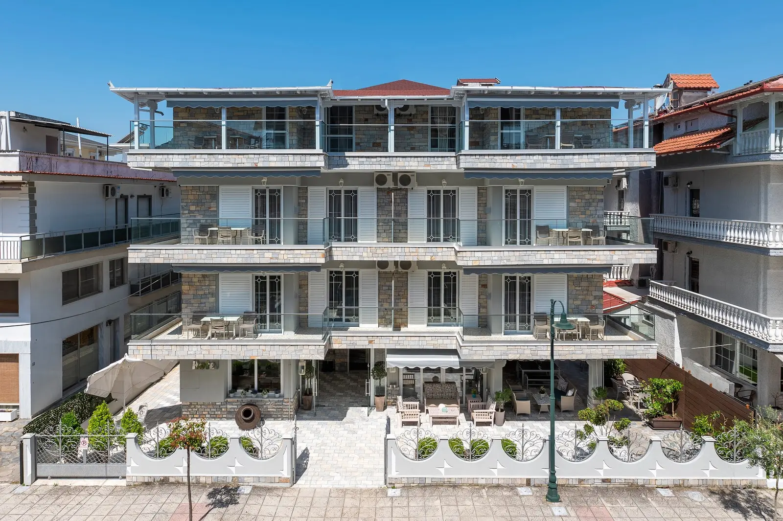 Фасадата на хотела с балкони и бяла ограда – Ouzas Luxury Hotel, Олимпийска ривиера
