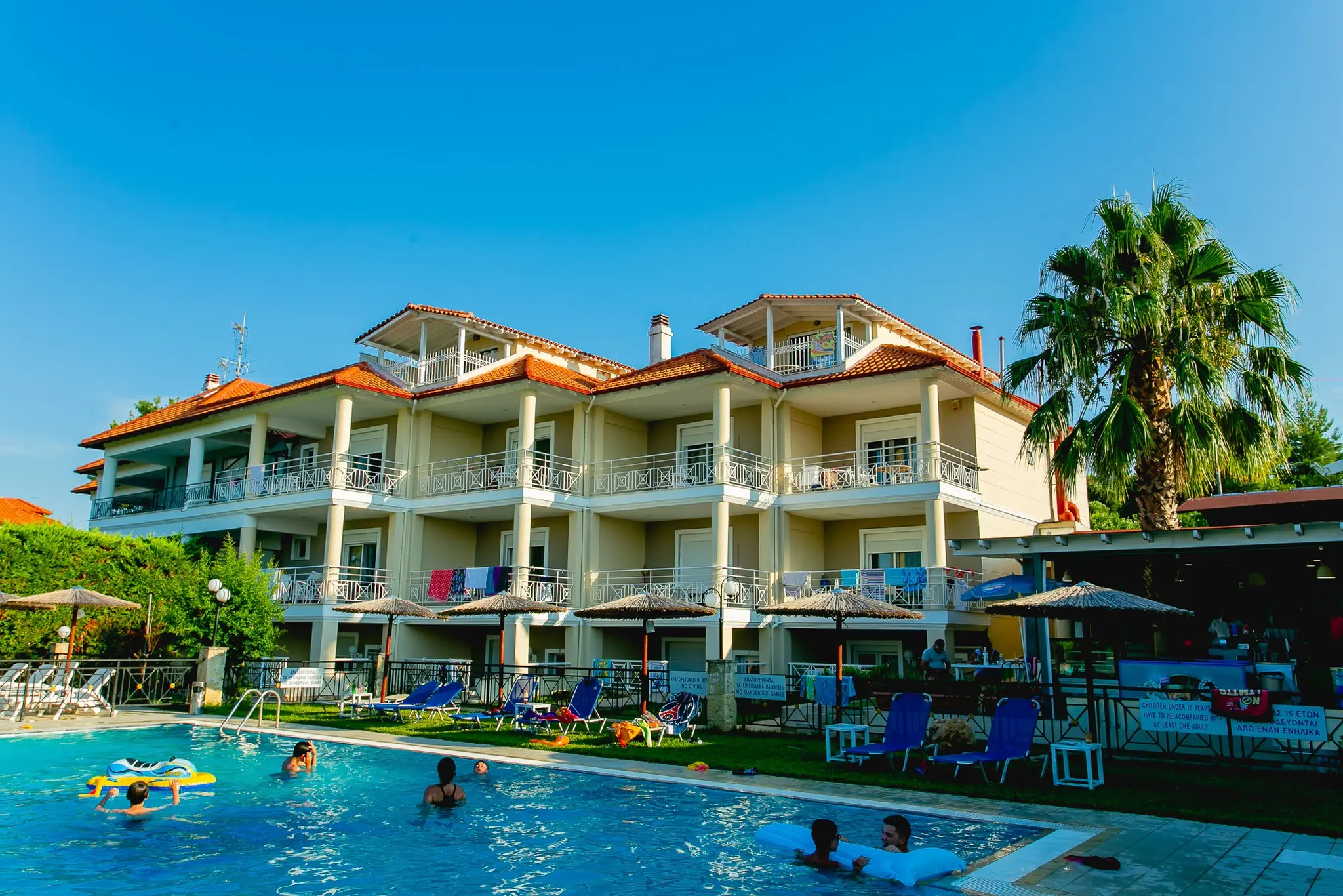 Сградите с балкони и басейнът с гости – Golden Residence Family Resort, Касандра