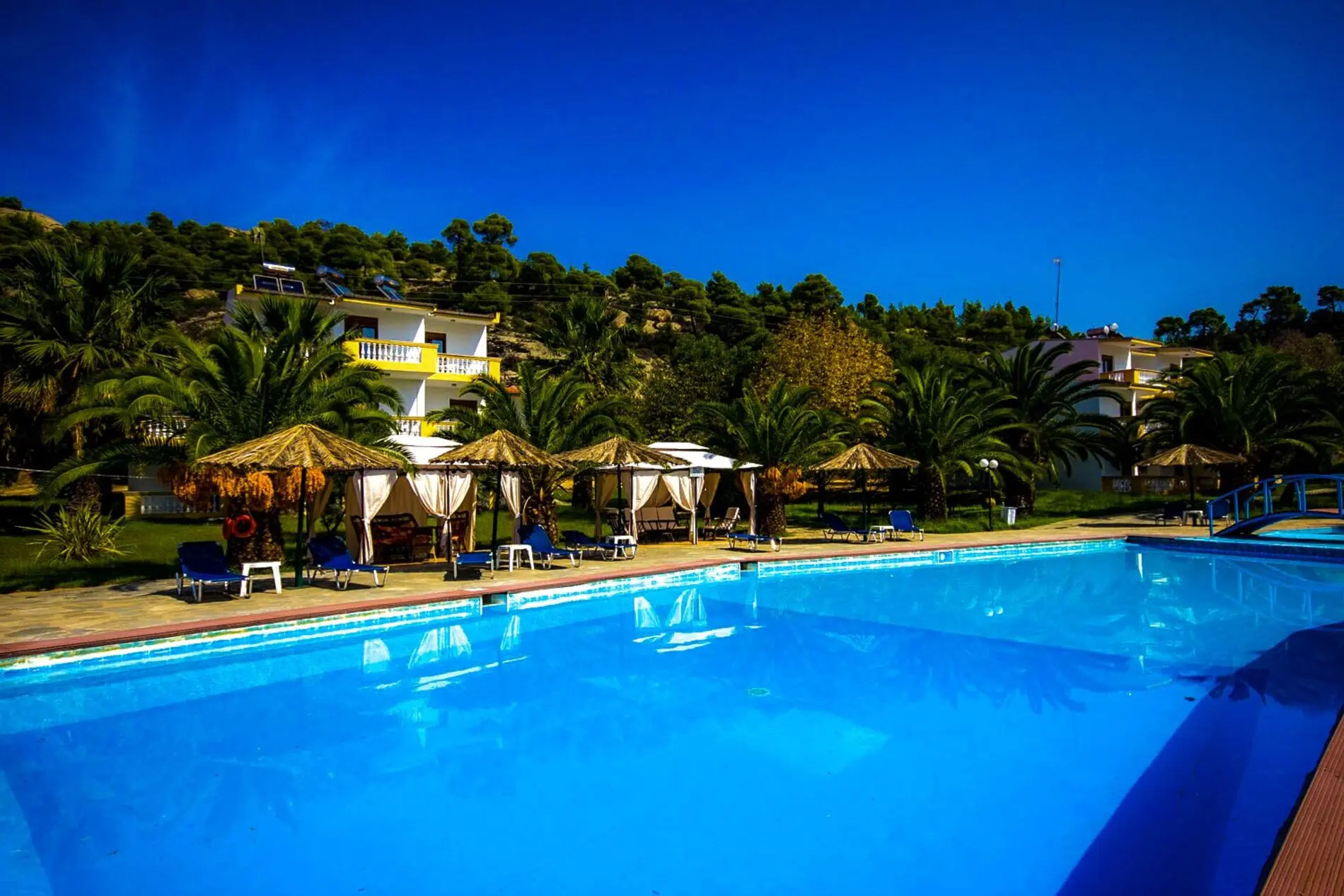 Голям басейн с беседки и шезлонги под залесения хълм – Koviou Holiday Village, Ситония