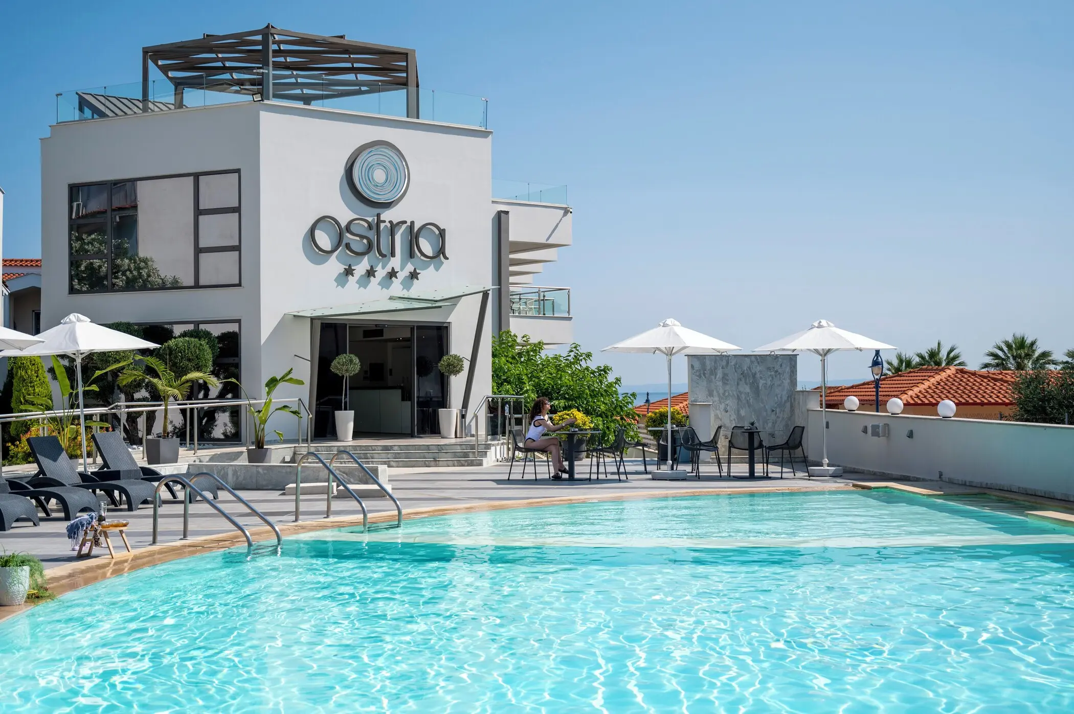 Басейнът пред модерната сграда с надписа на хотела – Ostria Sea Side, Касандра