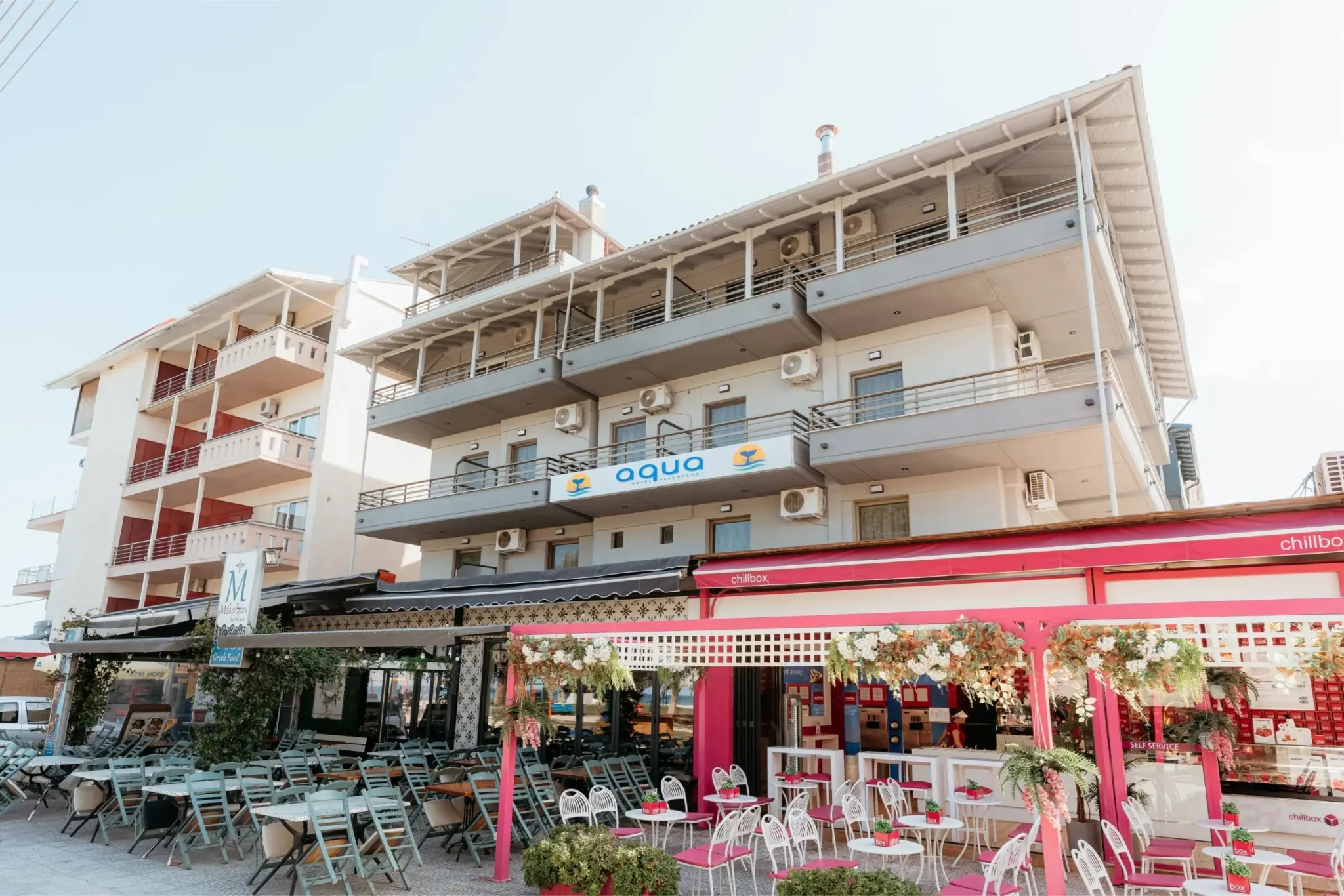 Фасада на хотела с ресторант и розова тента на партера – Aqua Beachfront Elegant Hotel, Олимпийска ривиера