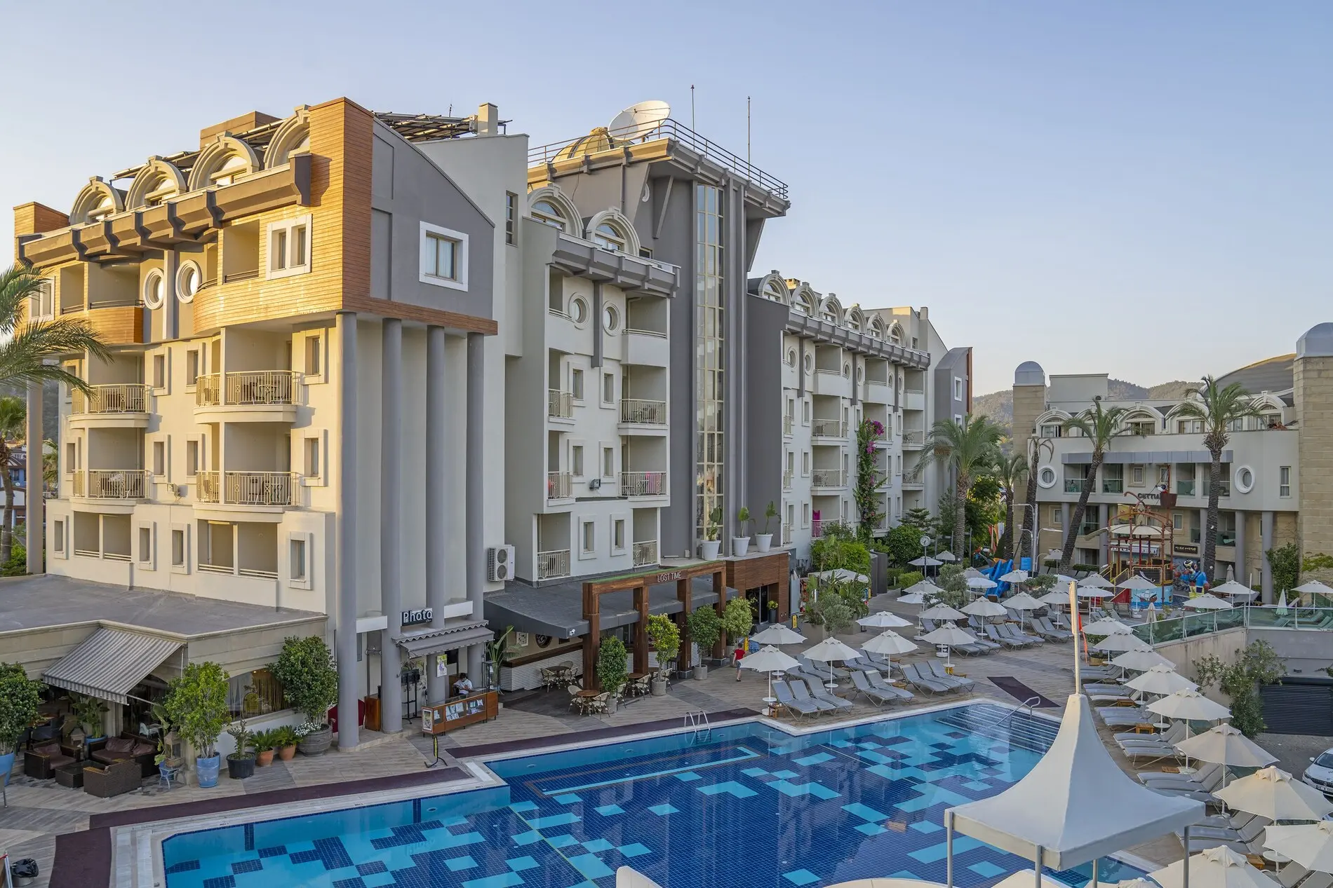 Фасада на хотела с външен басейн и шезлонги пред сградата – Grand Cettia Hotel, Мармарис