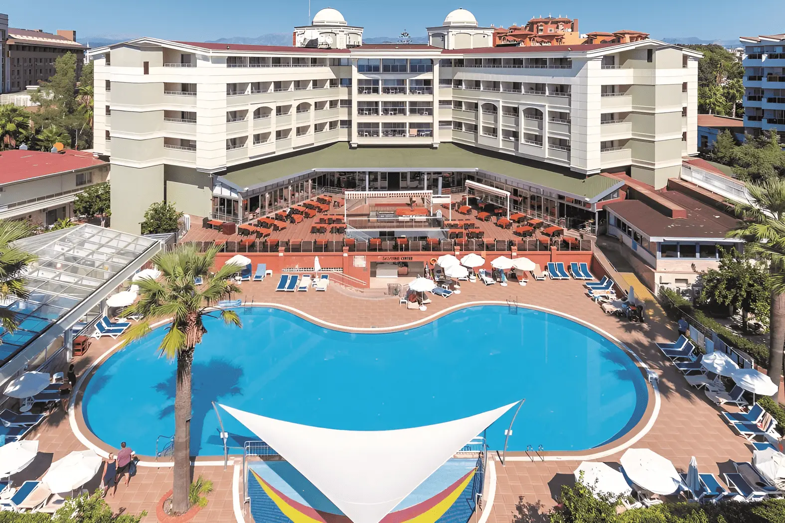 Извит басейн с бели платнени сенници пред сградата на комплекса – Seher Kumkoy Star Resort & SPA, Сиде
