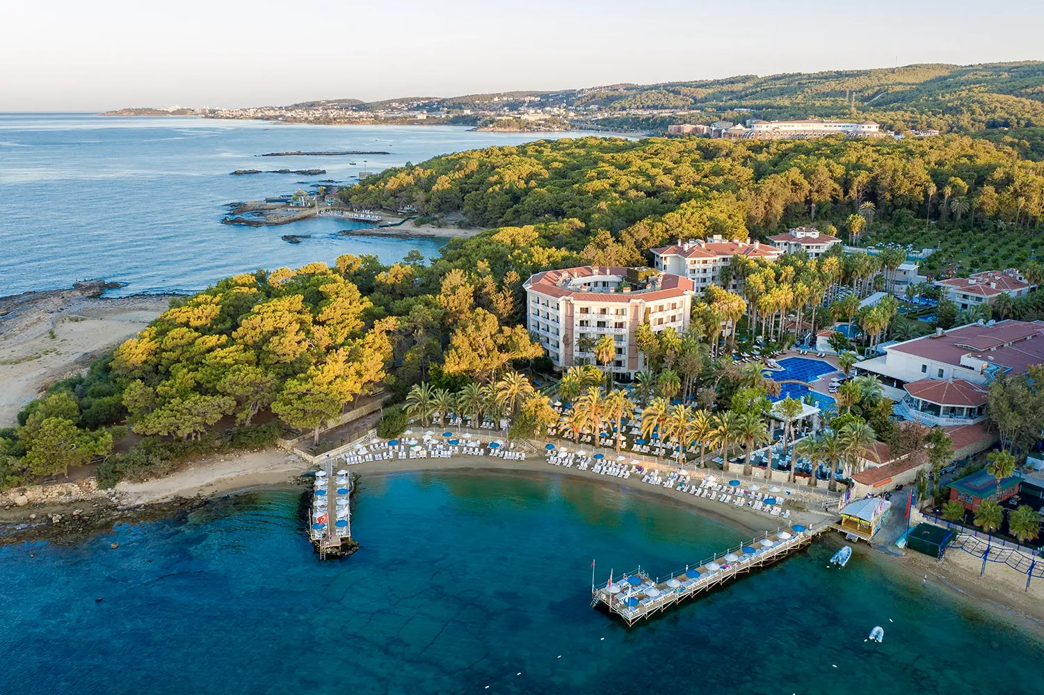 Въздушен изглед към комплекса сред боровете, плажа и двата понтона – Utopia Resort & Residence, Алания