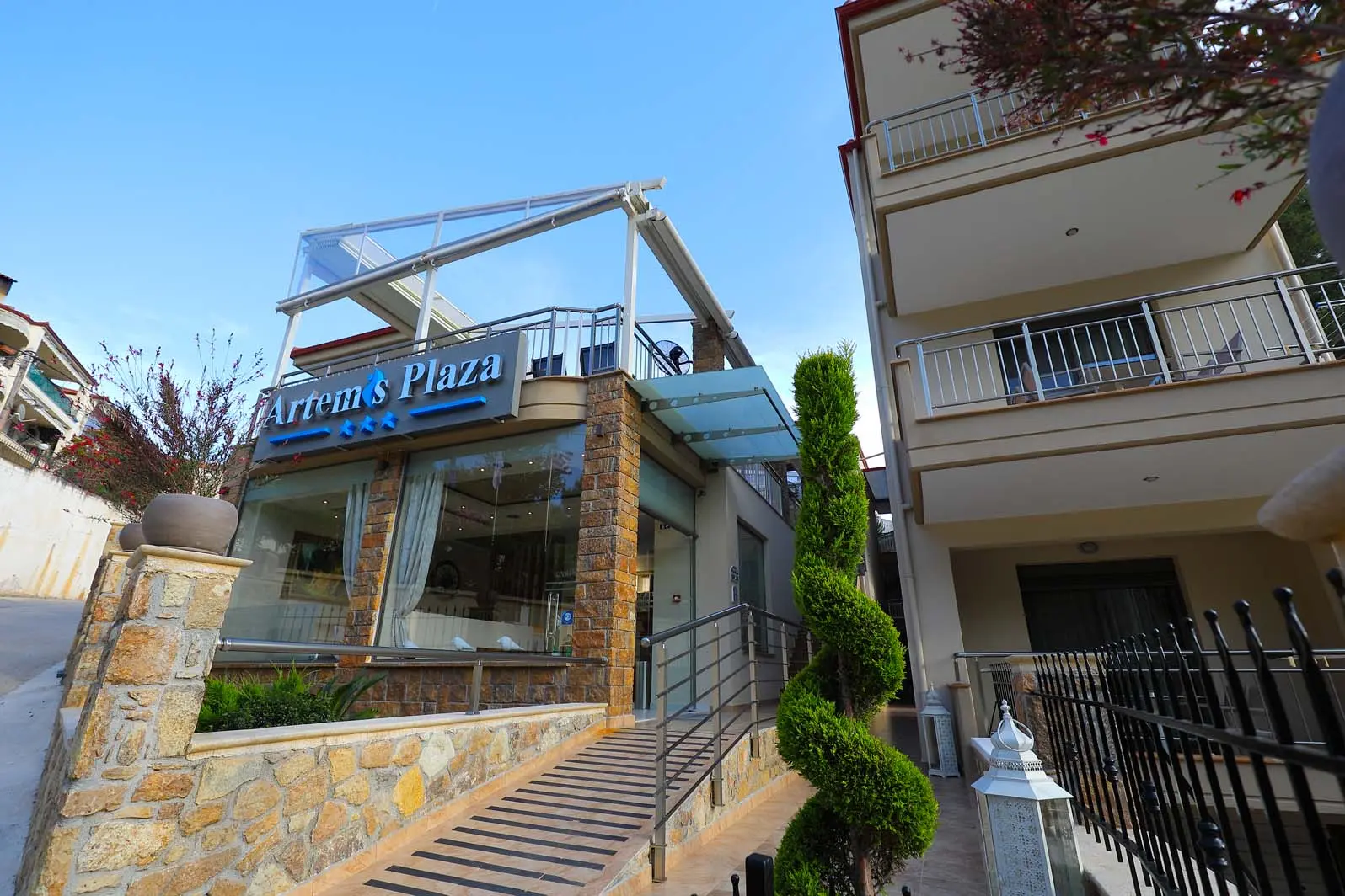Сградата на хотела със стъпала и зеленина отпред – Artemis Plaza, Касандра