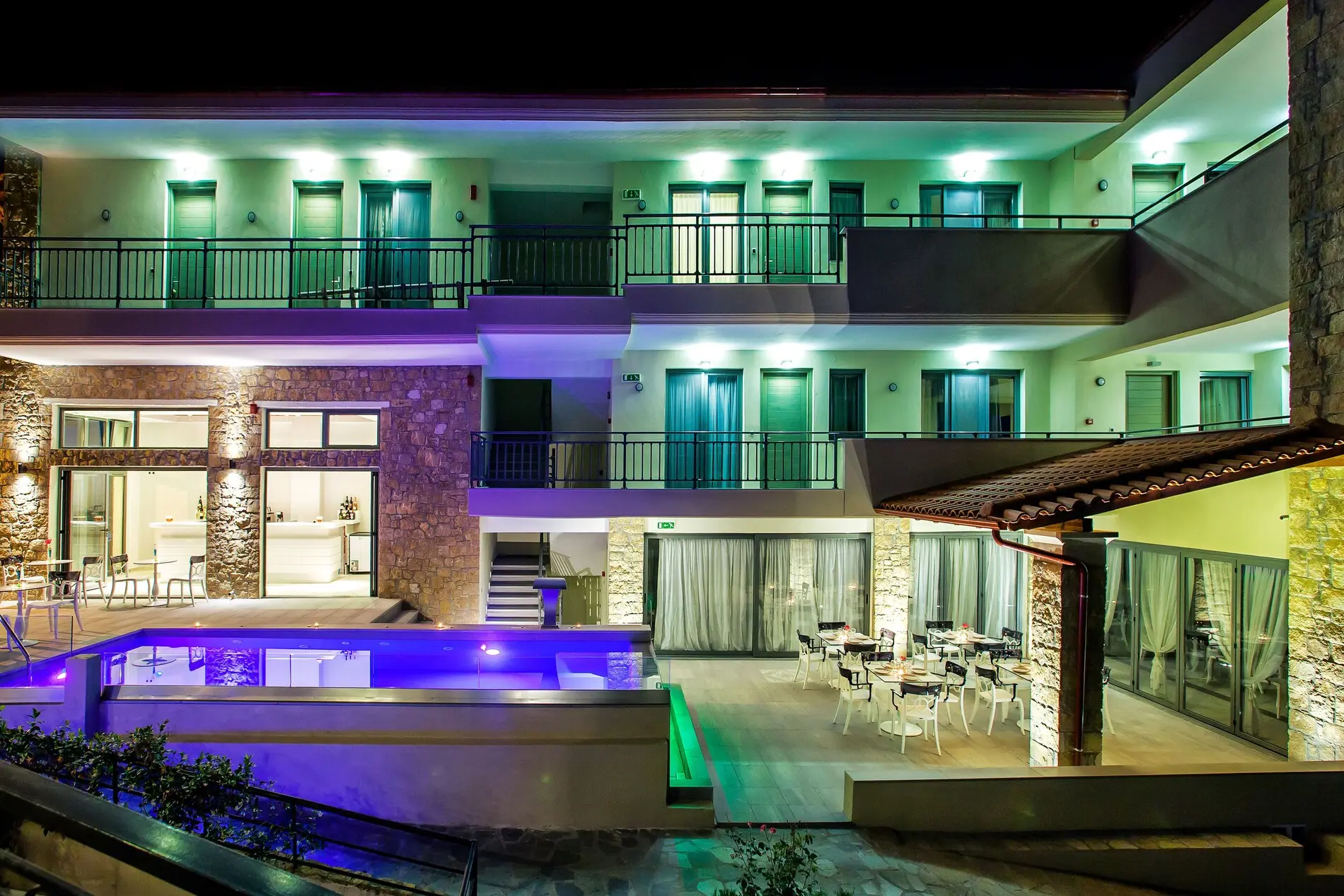 Осветената сграда с басейна и балконите вечер – Core Hotel, Касандра