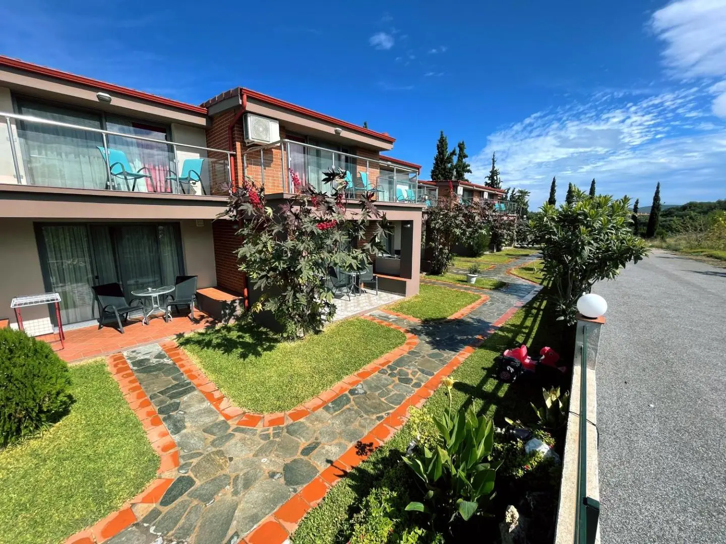 Сграда с балкони и цветна градина с каменна пътека – Village Mare Residence, Ситония