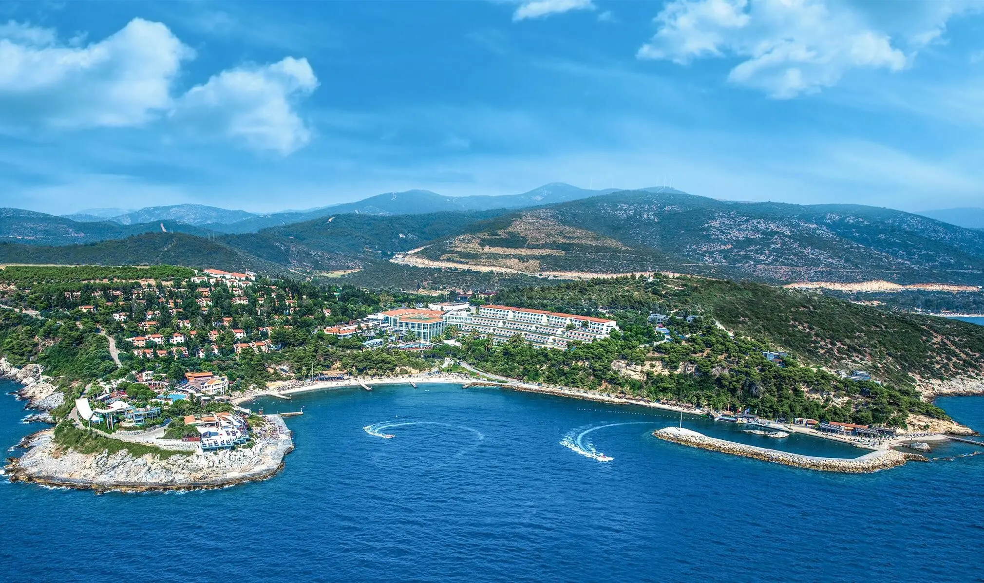 Панорама от въздуха на залива Чамлиманъ с марината и боровата гора – Pine Bay Holiday Resort, Кушадасъ