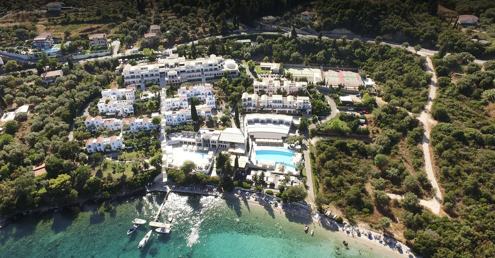 Въздушен изглед към комплекса с басейн и тюркоазения бряг – Porto Galini Seaside Resort & Spa, Лефкада