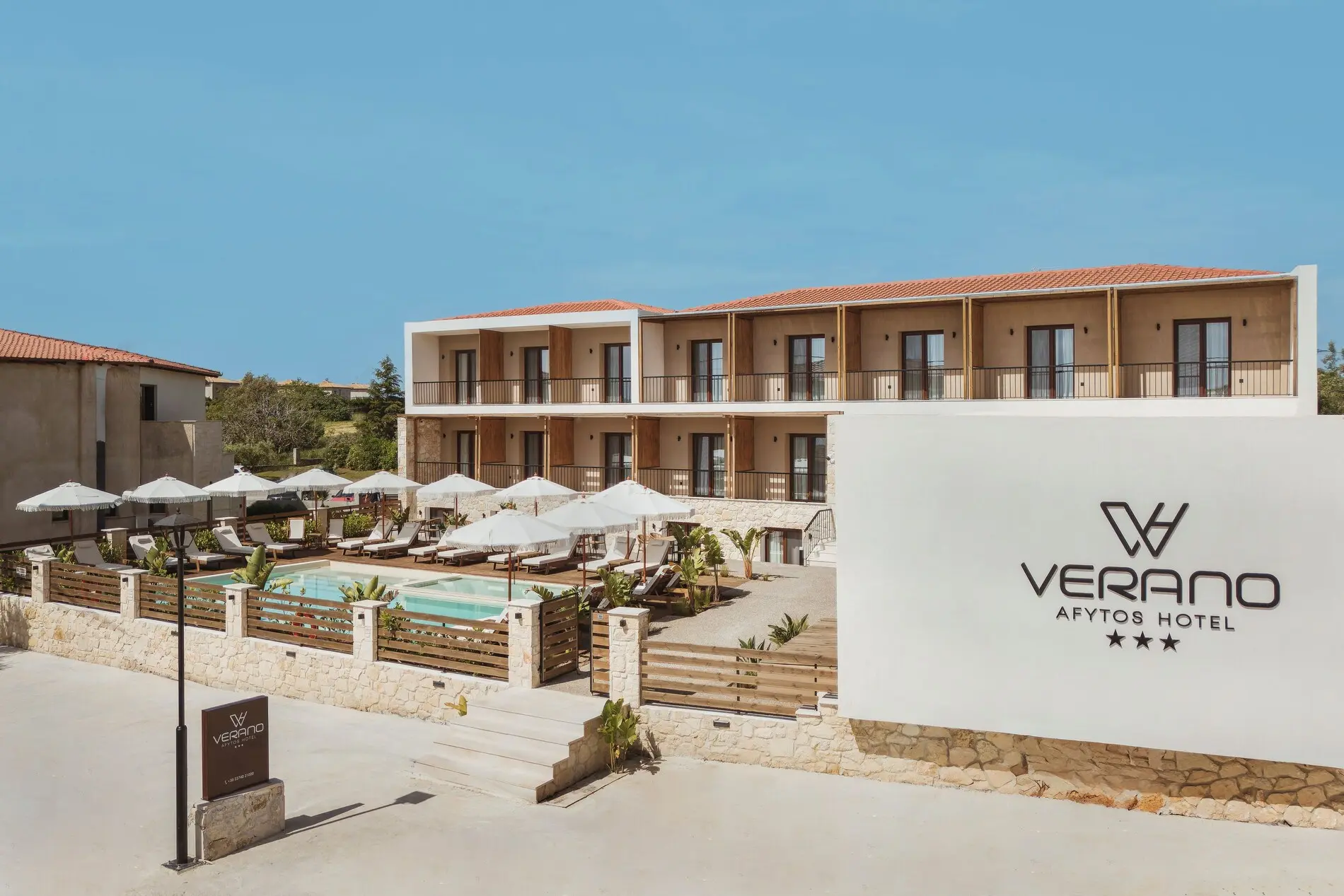 Табела с логото и сградата с басейна и чадъри – Verano Afytos Hotel, Касандра