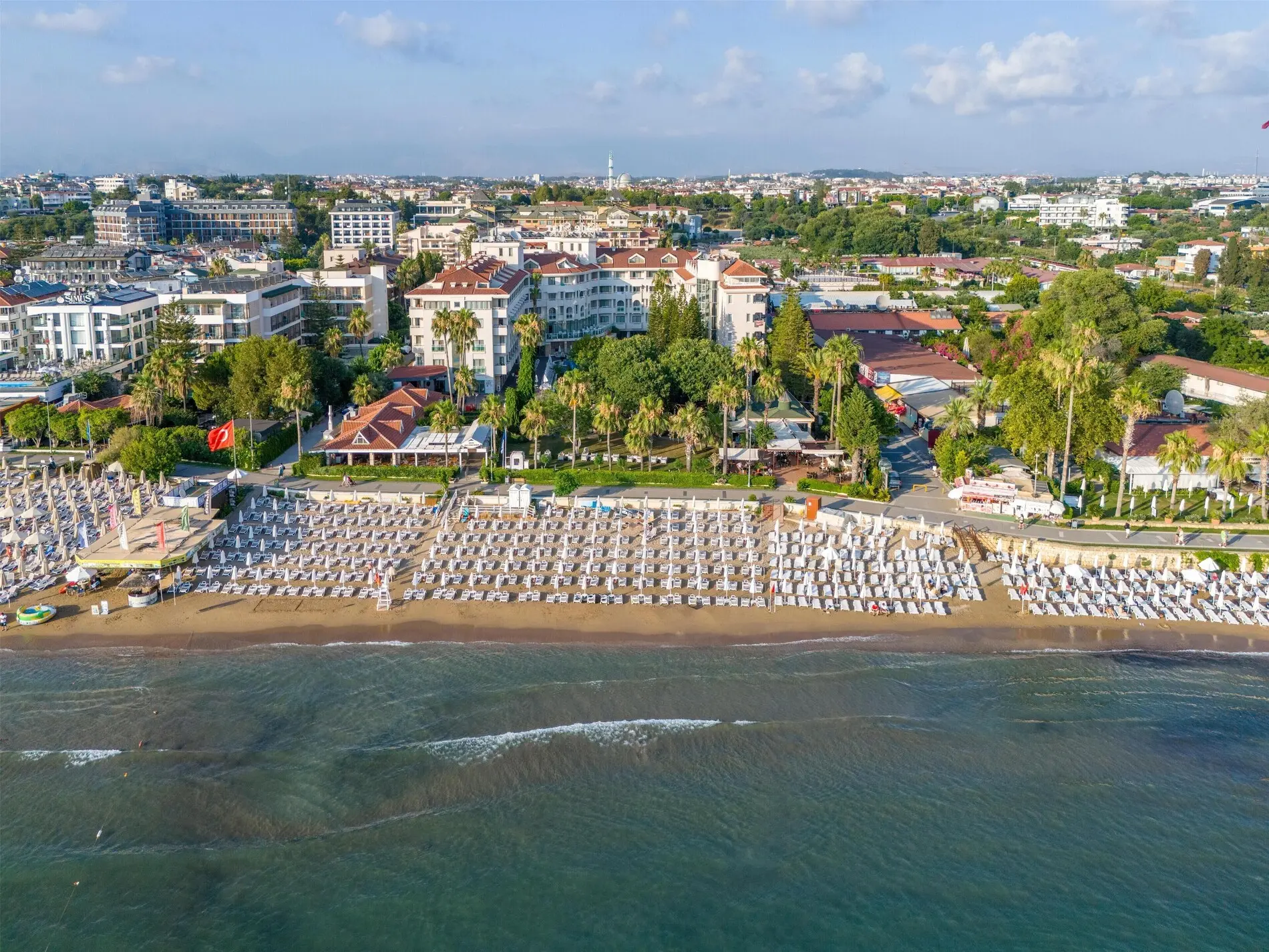 Плажът на хотела с редици чадъри и изглед към курорта от морето – Side Star Beach, Сиде