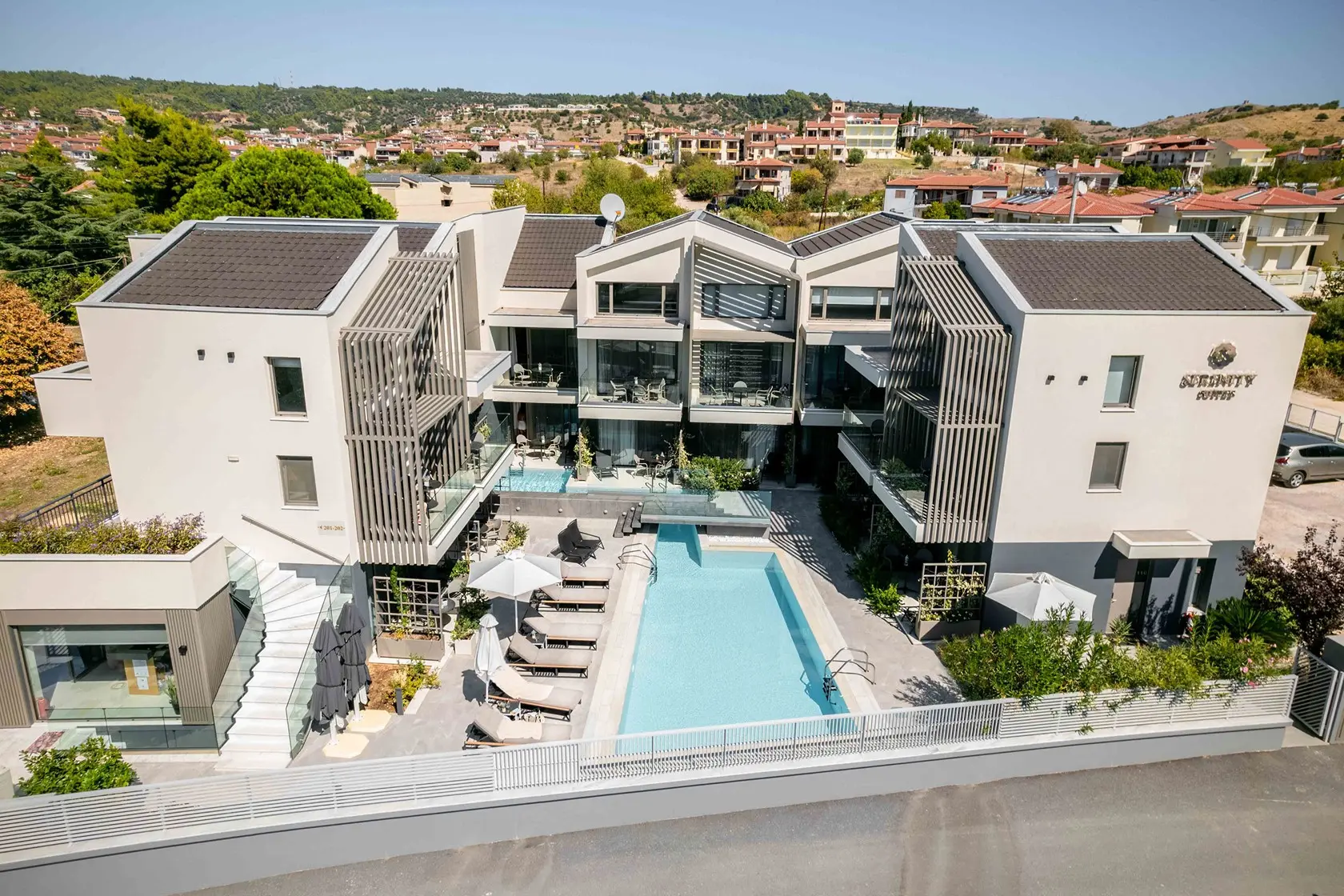 Модерните сгради и басейнът отвисоко – Serenity Suites, Ситония