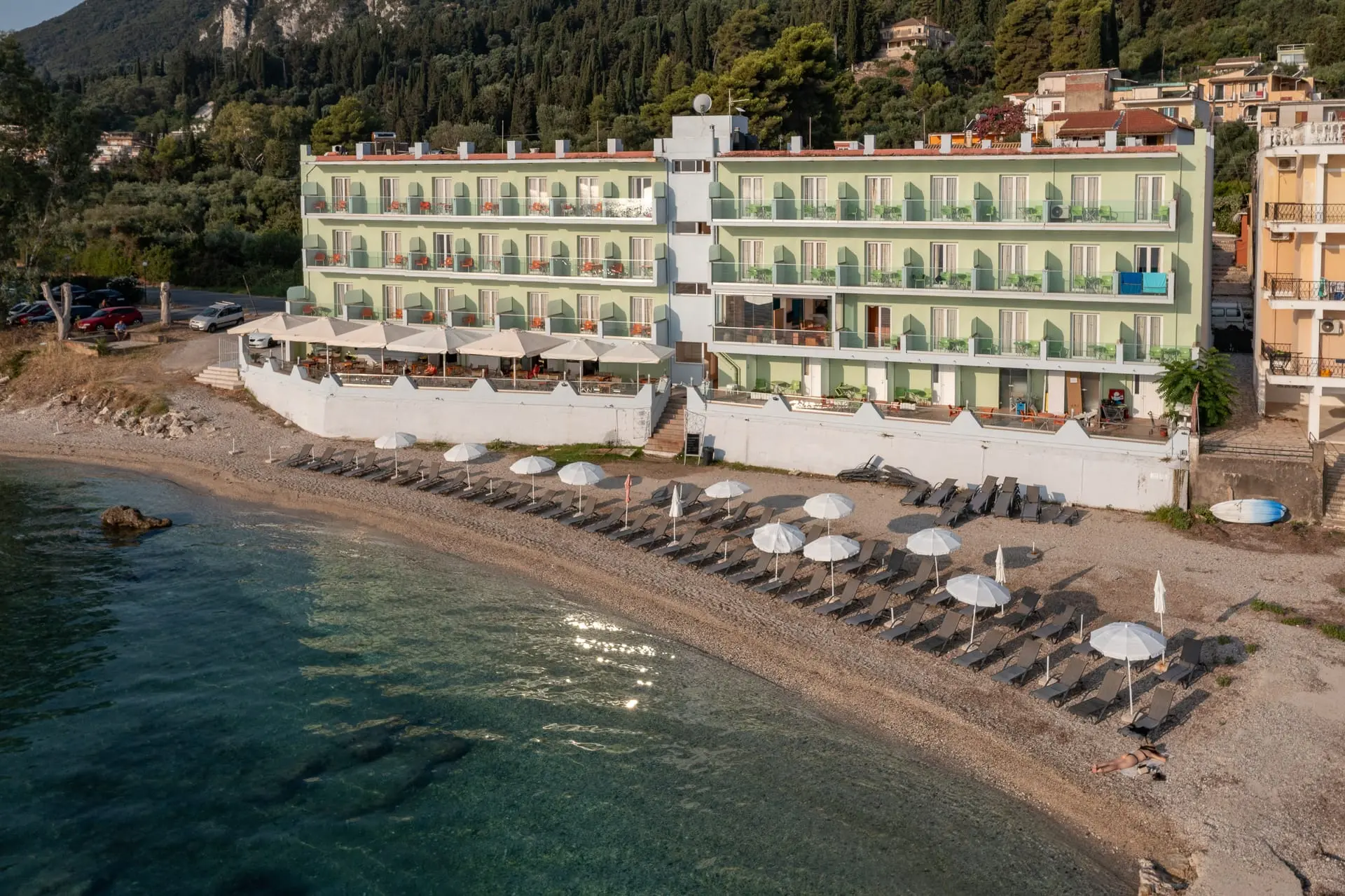 Хотелът над плажа с чадъри и бистро море отвисоко – Corfu Maris, Корфу