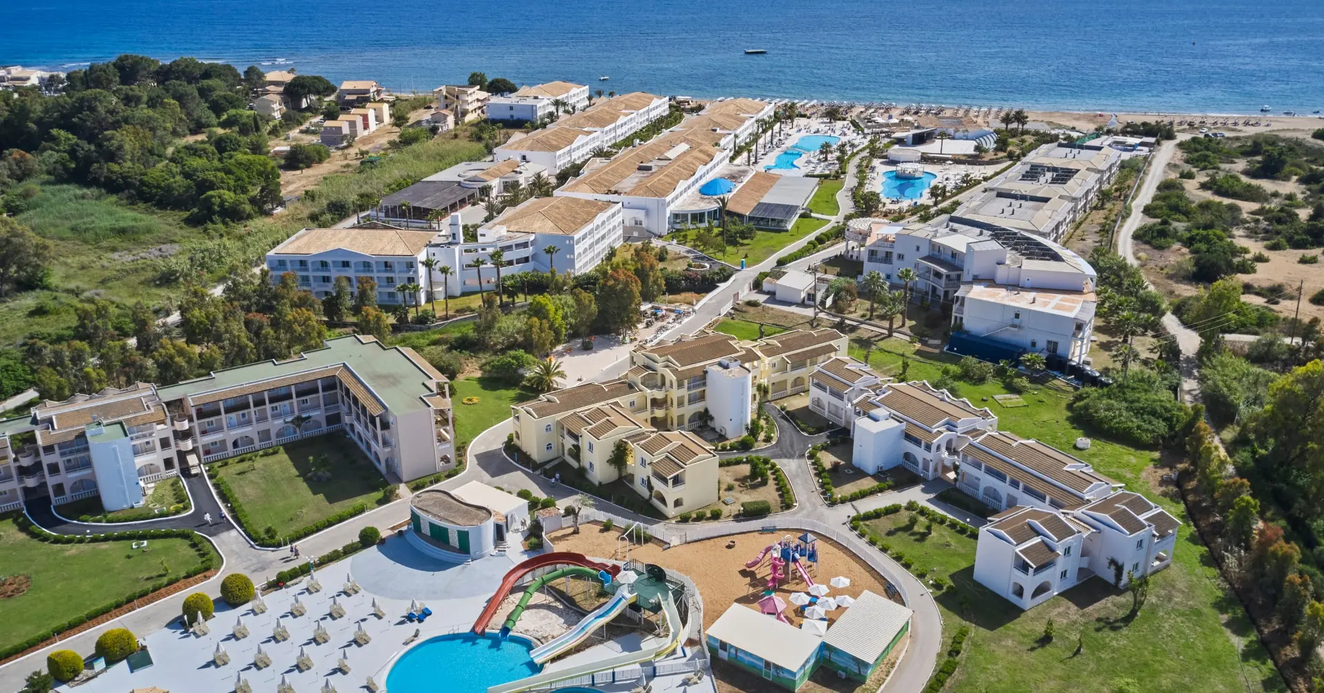 Въздушен изглед към комплекса с водни пързалки и морето – Sandy Beach Resort, Корфу