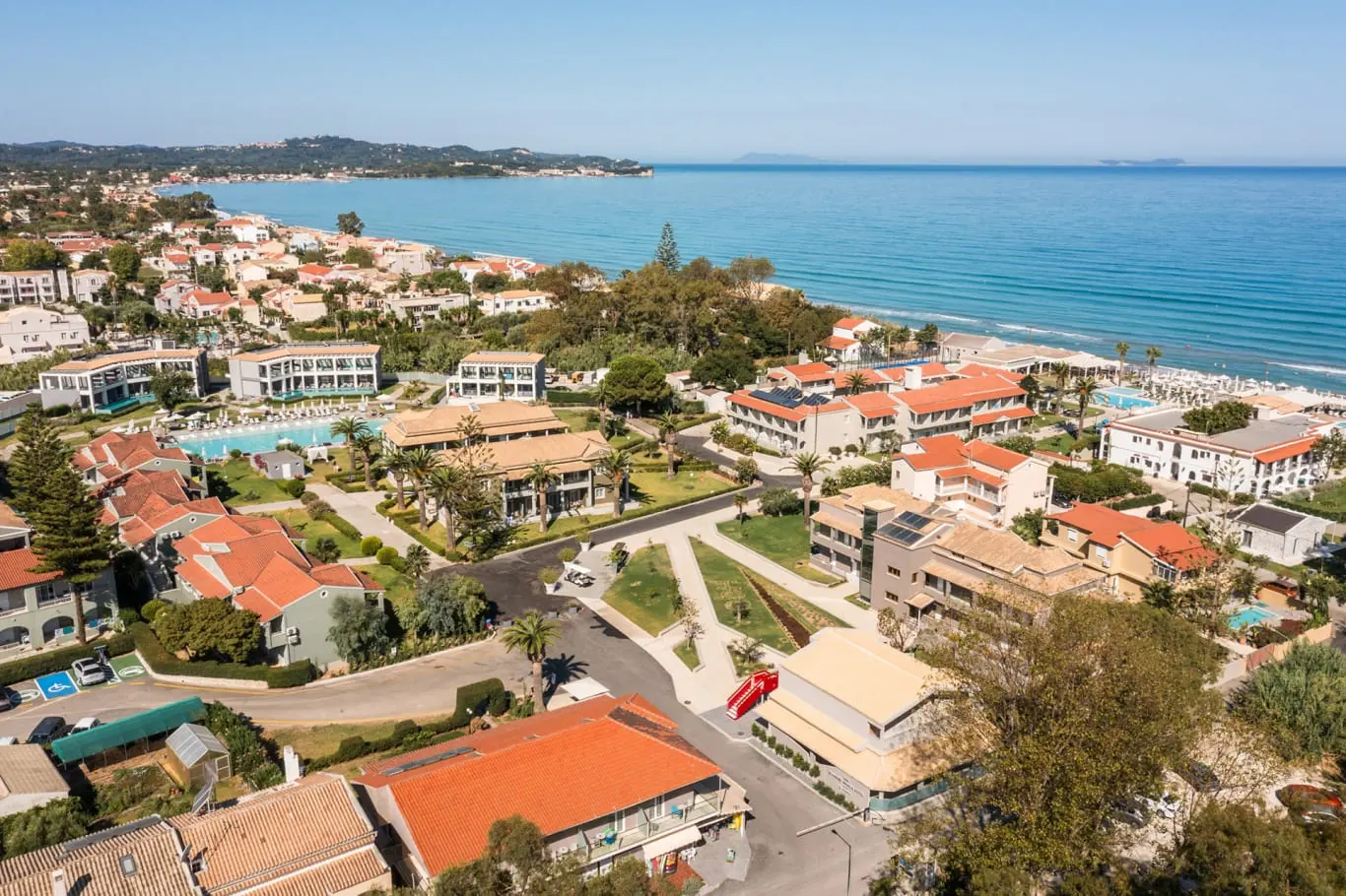 Въздушен изглед към курорта Ахарави с червени покриви и морето – Acharavi Beach, Корфу