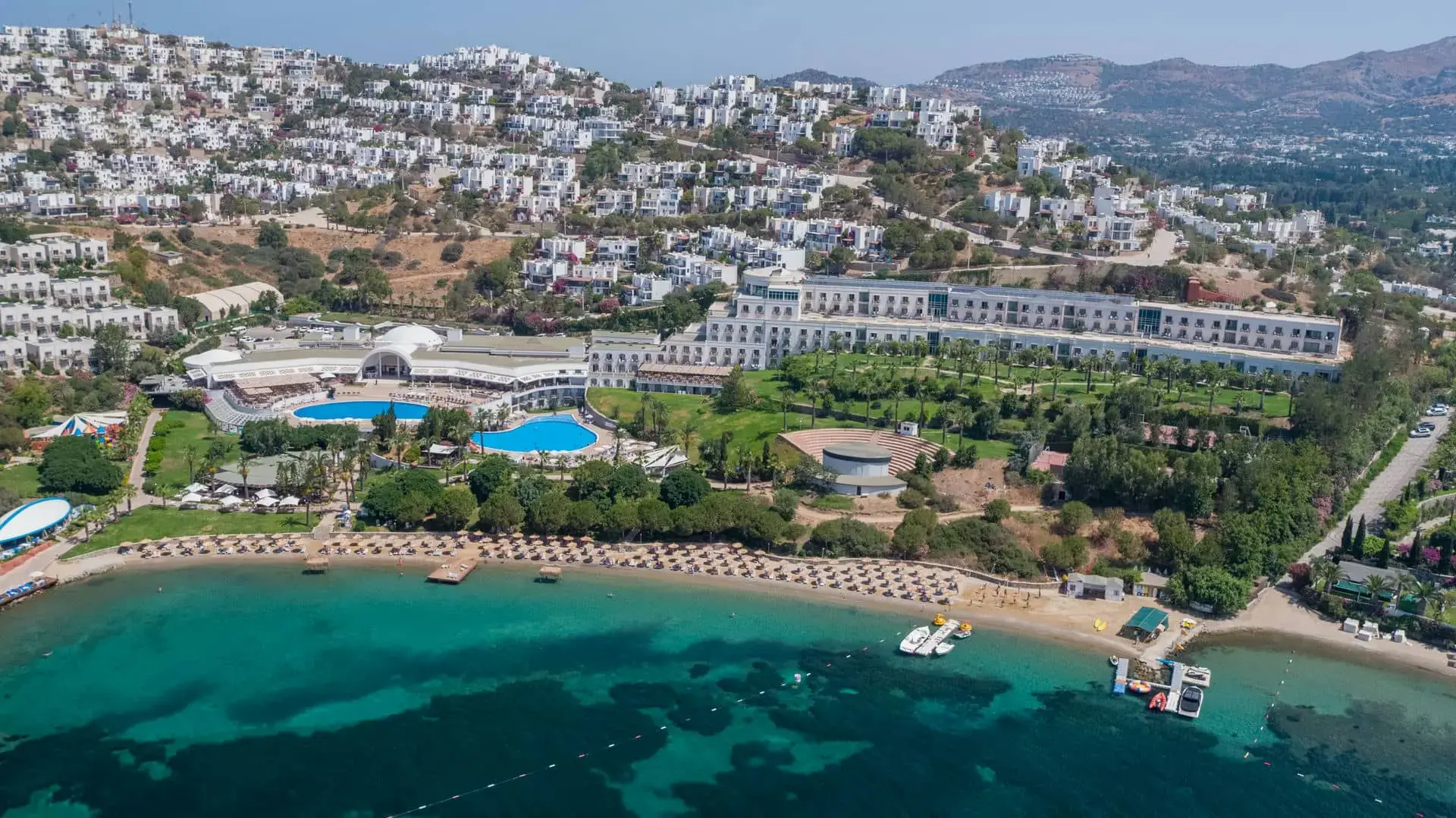 Панорамен изглед към хотела, бели сгради по склона и залива – Yasmin Bodrum Resort, Бодрум