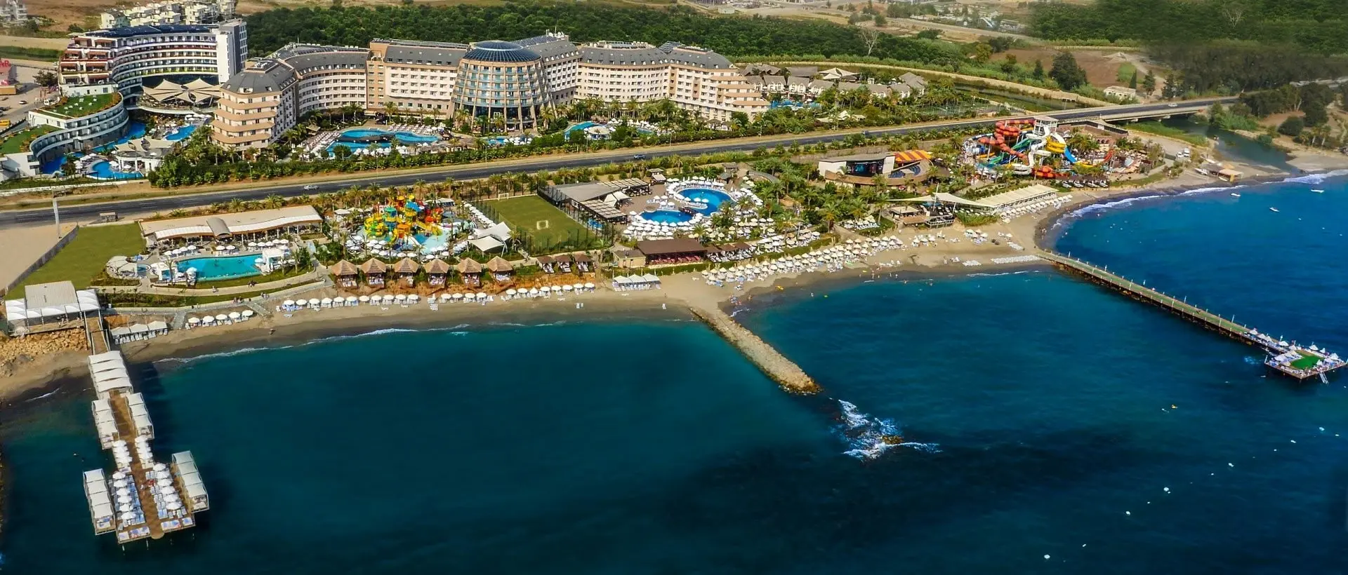 Комплексът от въздуха с пясъчния плаж, кея и аквапарка – Long Beach Resort & SPA, Алания
