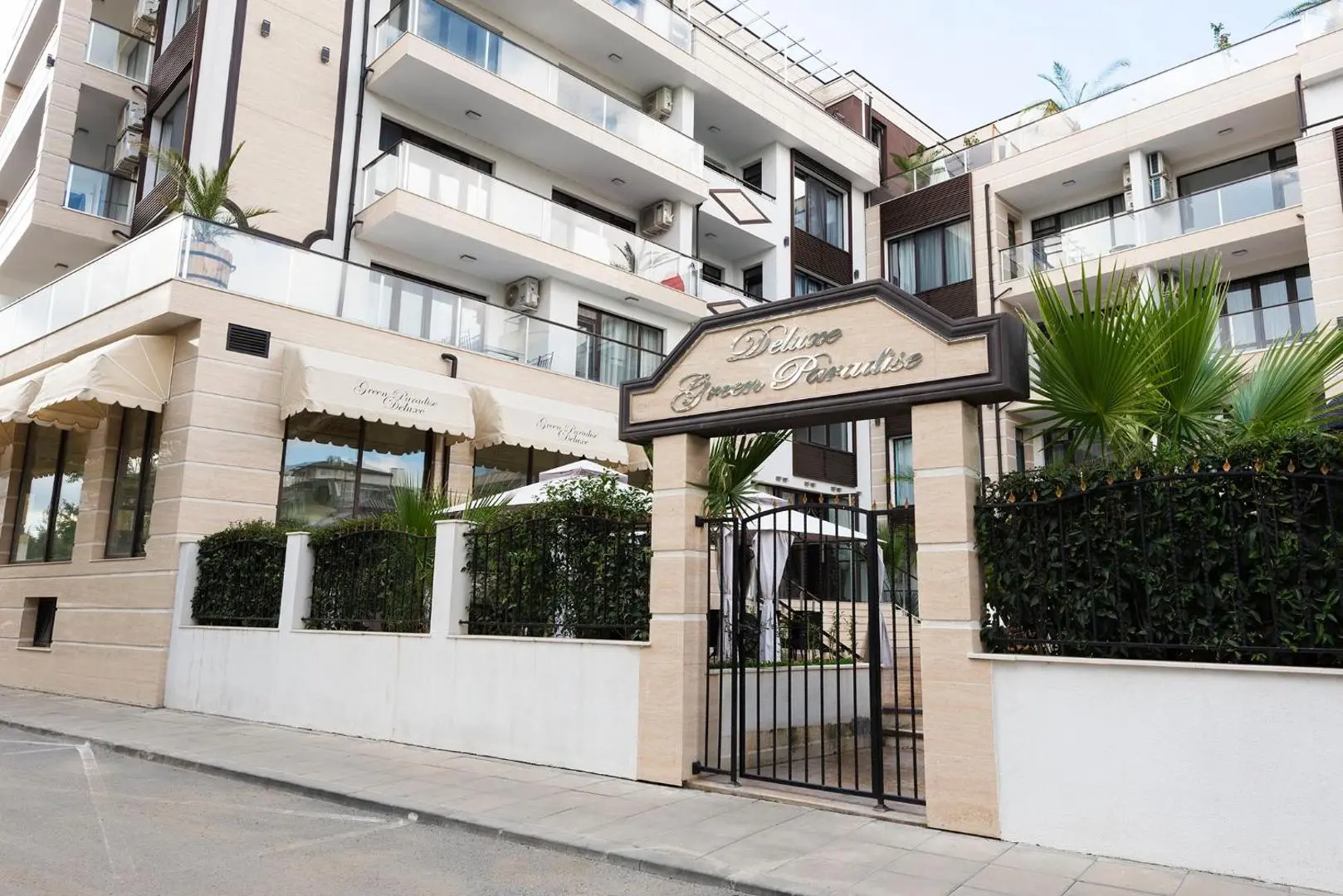 Входна врата с табела на комплекса и сградата с балкони над нея – Green Paradise Deluxe, Приморско