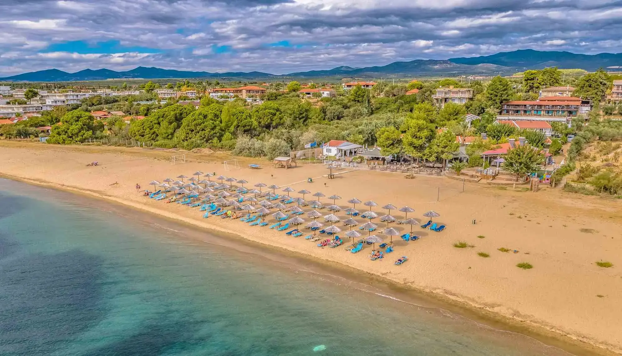 Въздушен изглед към широкия пясъчен плаж с чадъри и хотела – Coral Blue Hotel, Ситония