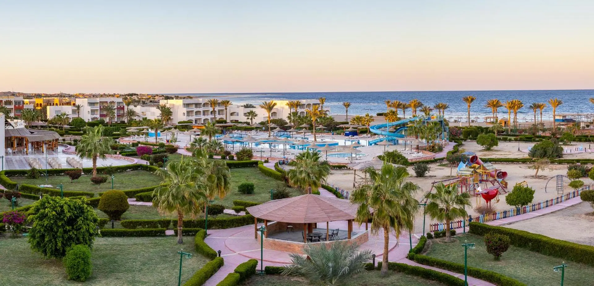 Градини, палми и басейни на комплекса, заснети отгоре по залез – Bliss Nada Beach Resort, Марса Алам