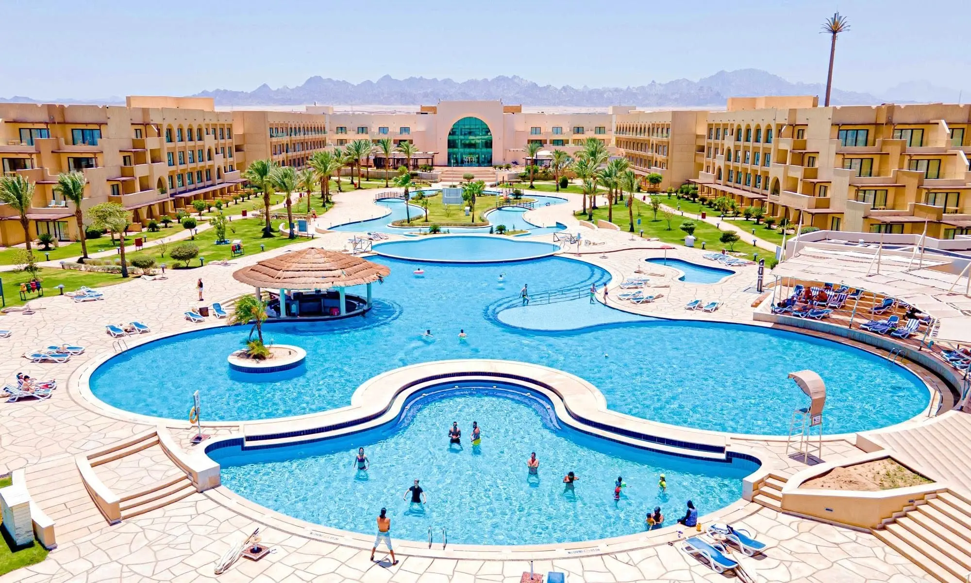 Голям извит басейн с бар на островче сред сградите – Mövenpick Waterpark Resort & Spa Soma Bay, Сома Бей
