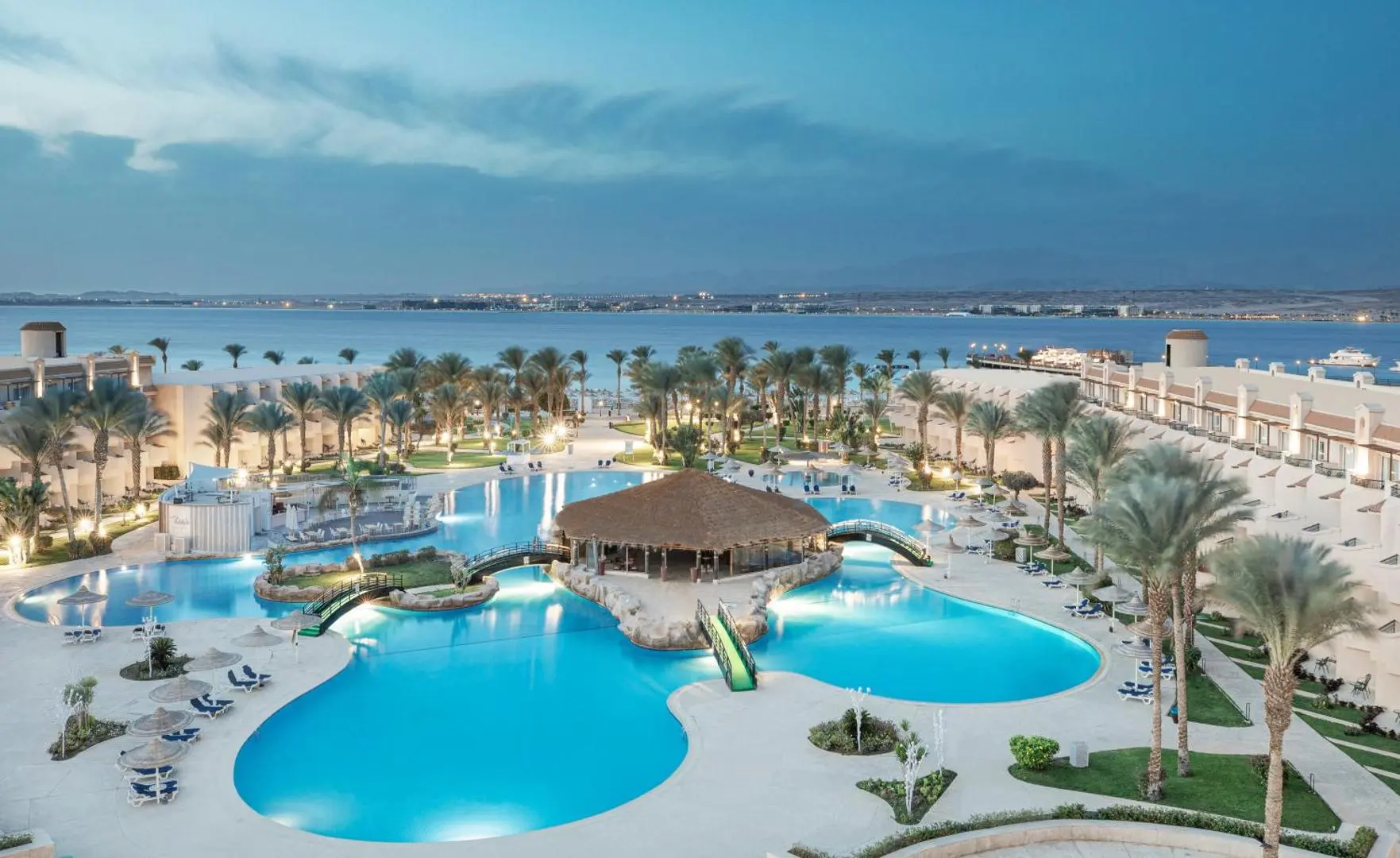 Изглед от високо към басейните с бар под сламен покрив и морето – Pyramisa Beach Resort Sahl Hasheesh, Сал Хашиш