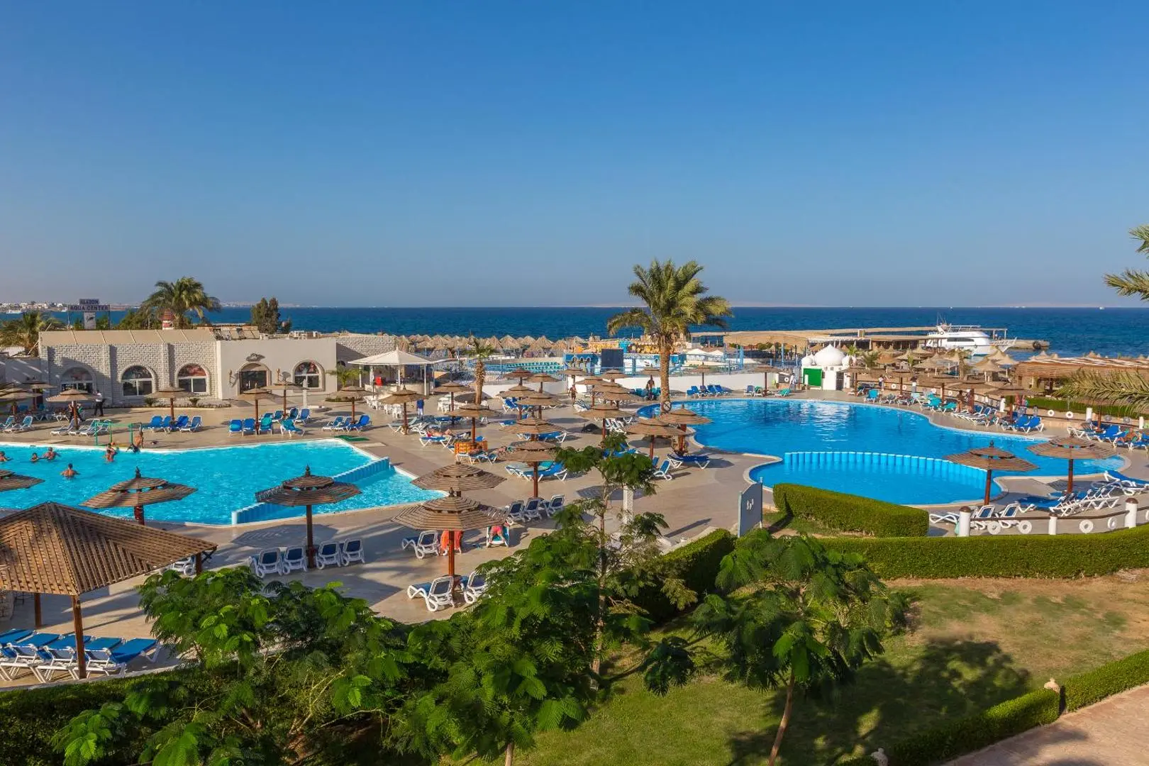 Панорама към басейните, градините с палми и морето на хоризонта – Aladdin Beach Resort, Хургада