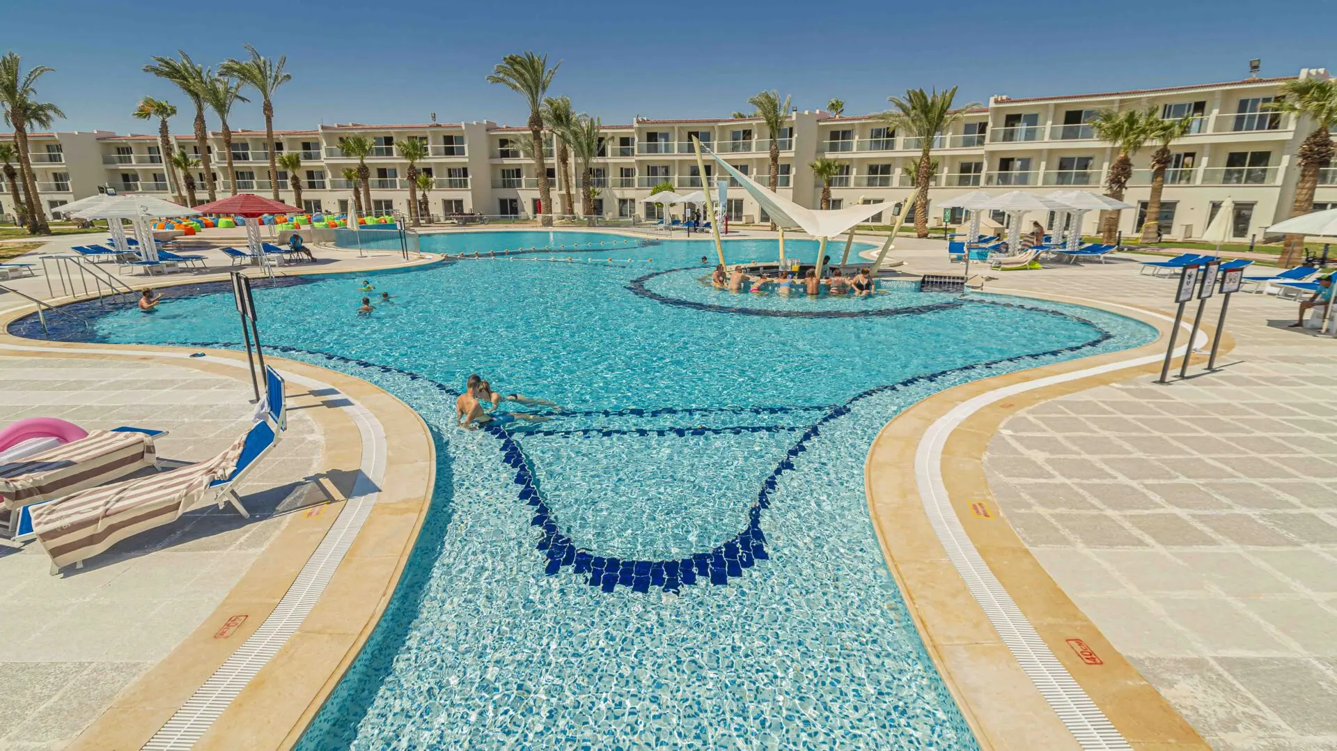 Басейн с мозаечни плочки, палми и жилищни сгради с балкони – Amarina Abu Soma Resort & Aquapark, Сома Бей