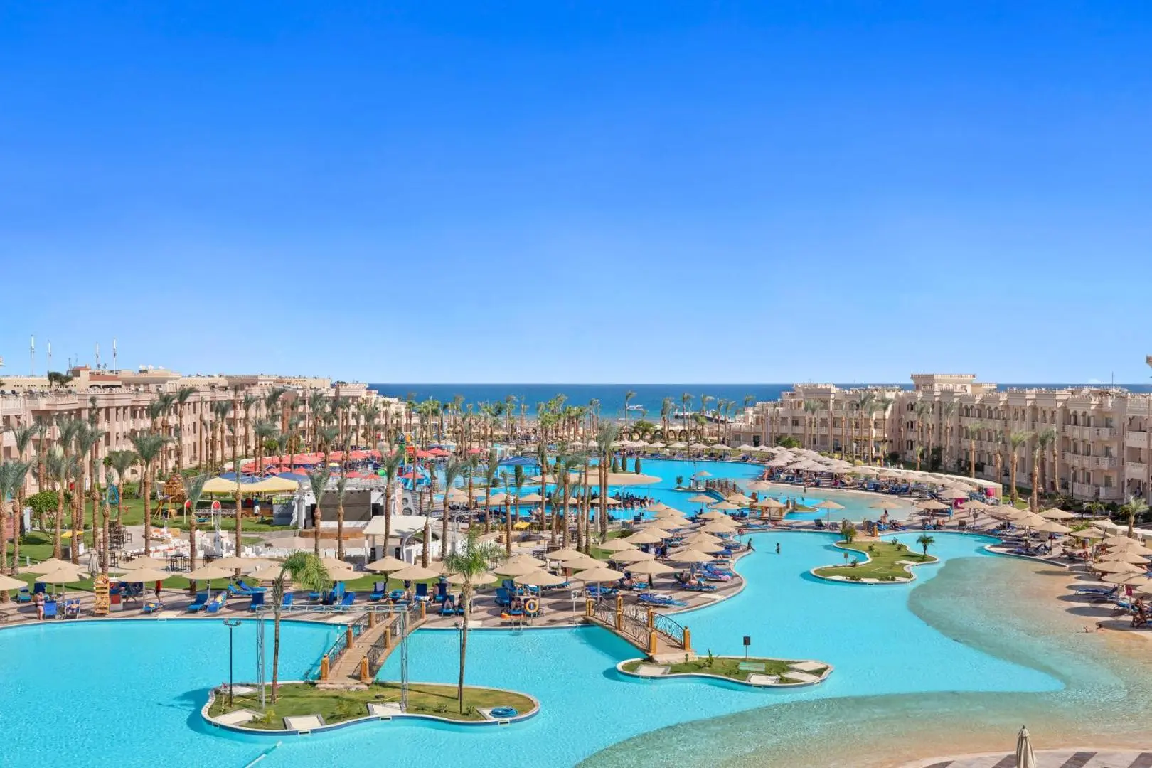 Изглед отгоре към лагунните басейни с островчета, палми и морето – Pickalbatros Palace Resort - Hurghada, Хургада