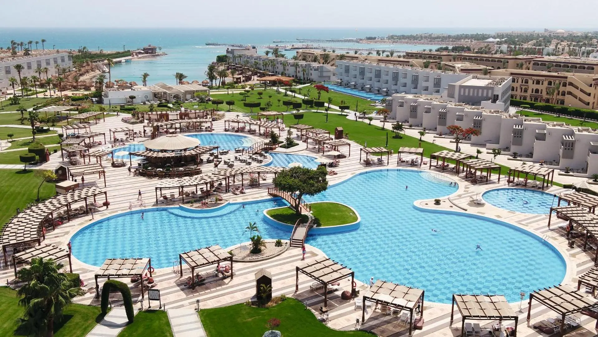 Изглед отгоре към басейните с беседки, градините и лагуната – Sunrise Crystal Bay Resort, Хургада