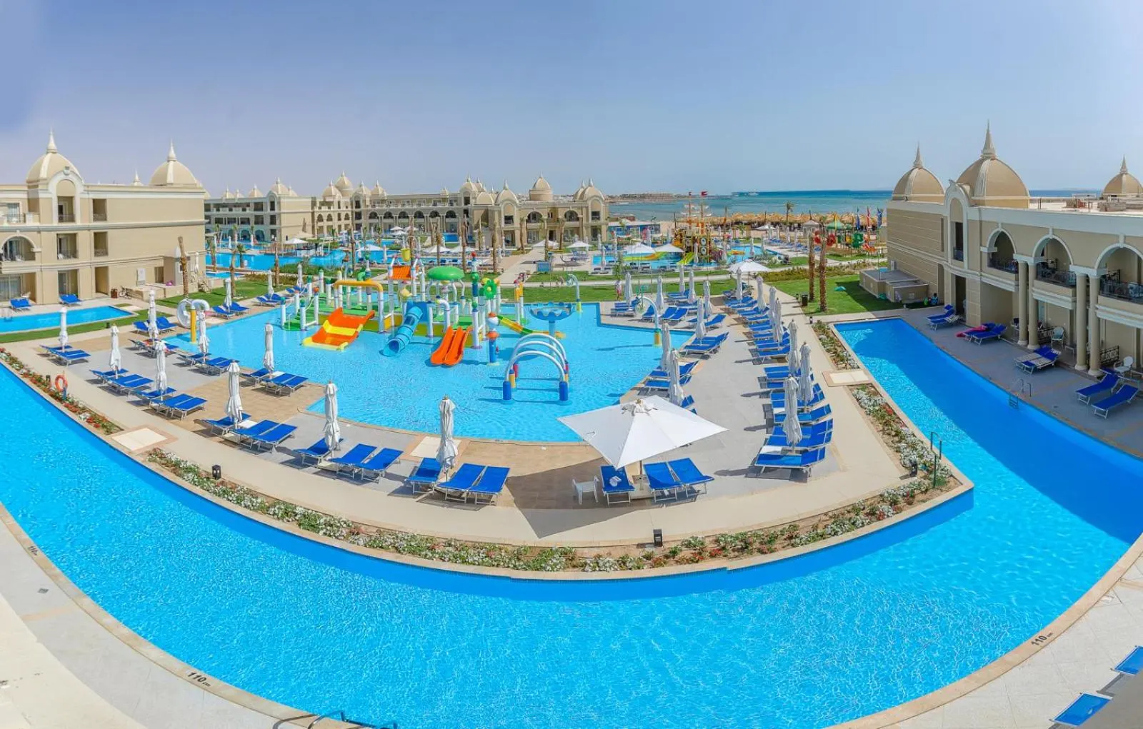 Панорама към басейновия комплекс с водни пързалки и морето – Titanic Royal Resort, Хургада