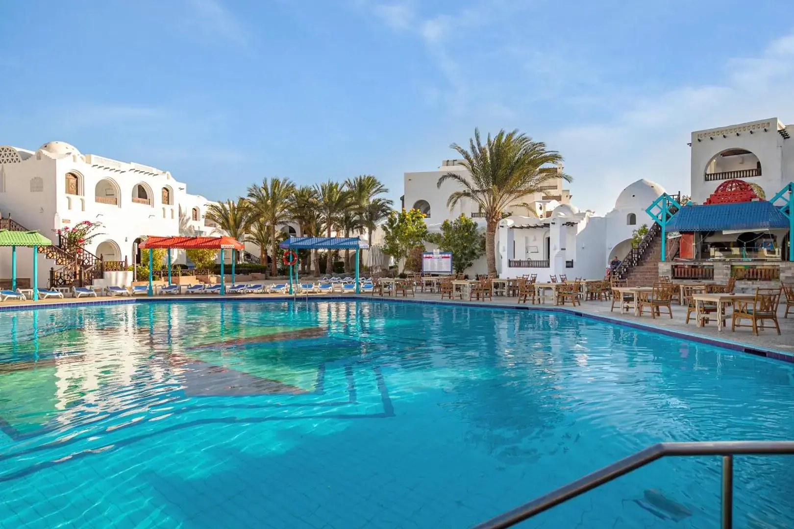 Голям басейн с тюркоазена вода пред белите нубийски сгради – Arabella Azur Resort, Хургада
