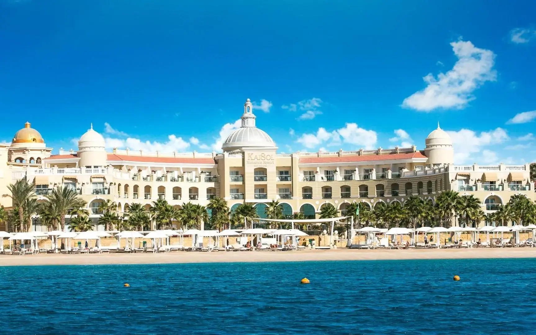 Сградите с бели куполи и плажът с палми, гледани от морето – KaiSol Romance Resort Sahl Hasheesh (16+), Сал Хашиш