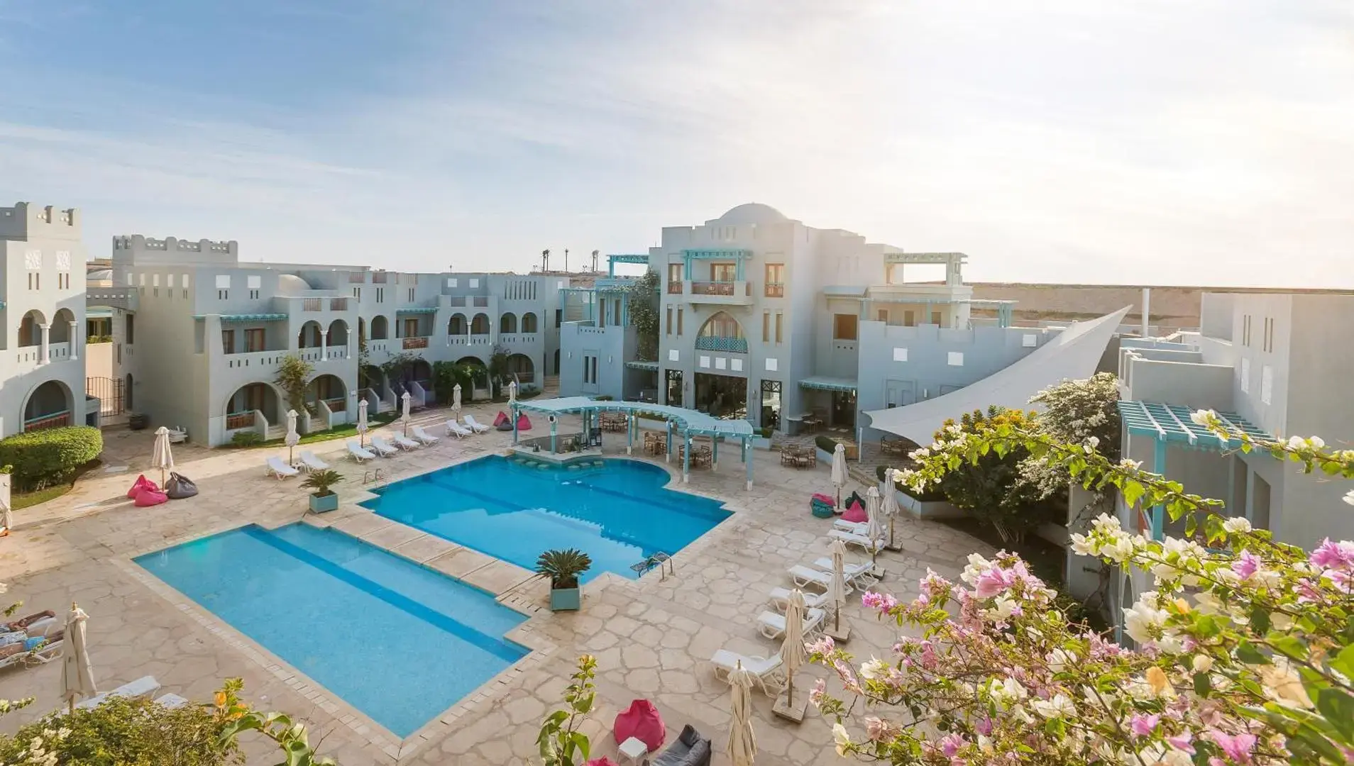 Открит басейн сред бели сгради и цъфнали храсти, изглед отвисоко – Fanadir Hotel El Gouna, Ел Гуна