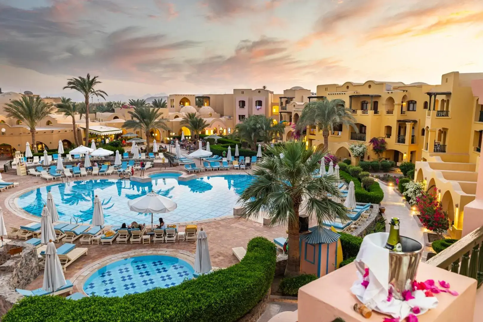 Басейн сред палми и сгради в нубийски стил по залез – Three Corners Rihana Resort, Ел Гуна
