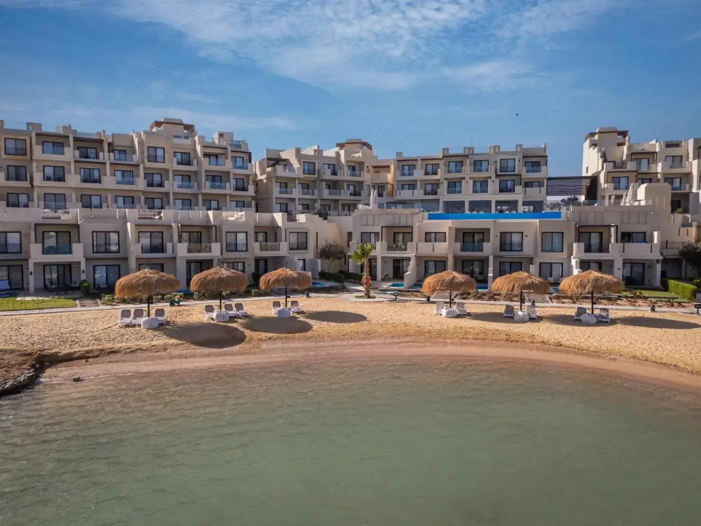 Сградите на хотела над пясъчния плаж в лагуната със сламени чадъри – CREEK Hotel & Residences El Gouna, Ел Гуна