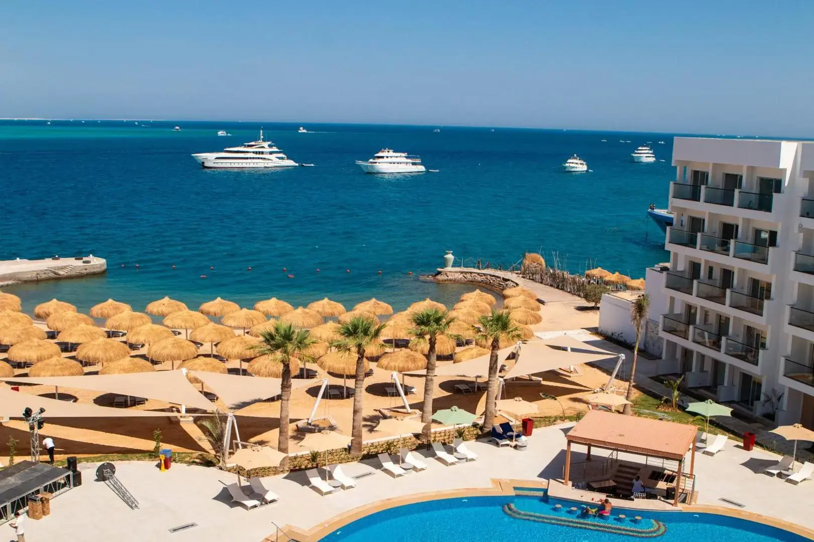 Изглед отгоре към плажа със сламени чадъри, басейна и яхти – Amarina Sapphire Beach Resort (Adults Only), Хургада