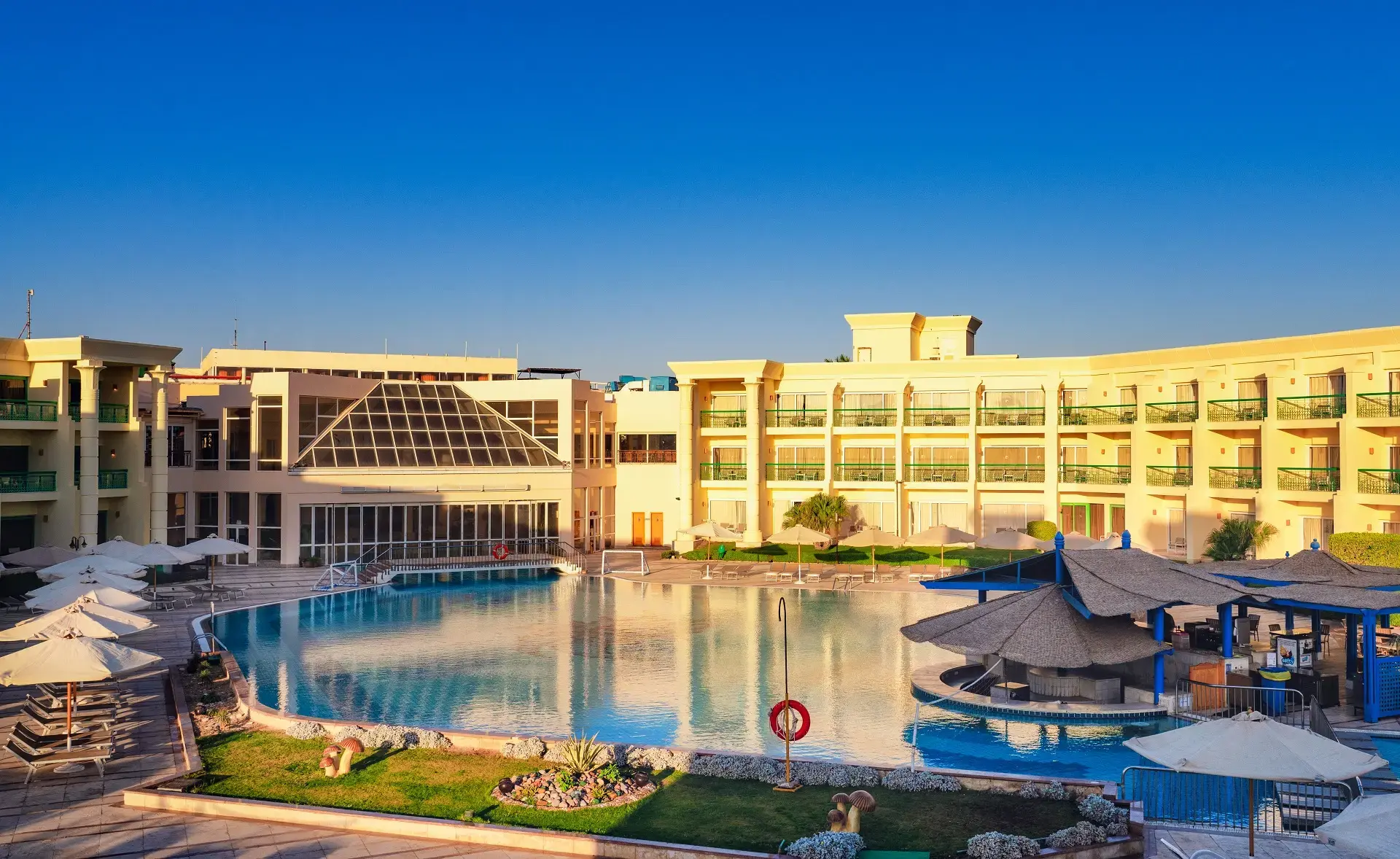Голям открит басейн пред основната сграда под синьо небе – Swiss Inn Resort Hurghada, Хургада