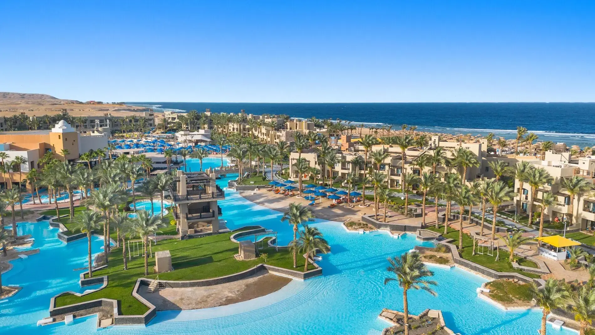 Изкуствената лагуна със зелени островчета и палми, морето на хоризонта – Pickalbatros Oasis Port Ghalib, Марса Алам