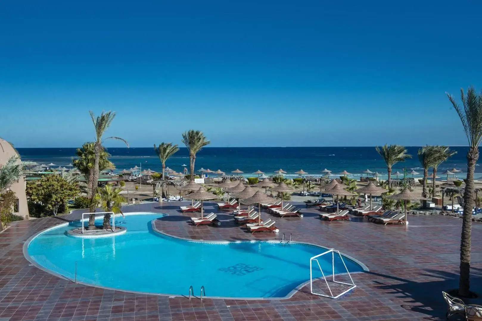Кръгъл басейн с шезлонги и палми с изглед към Червено море – Shams Alam Beach Resort, Марса Алам