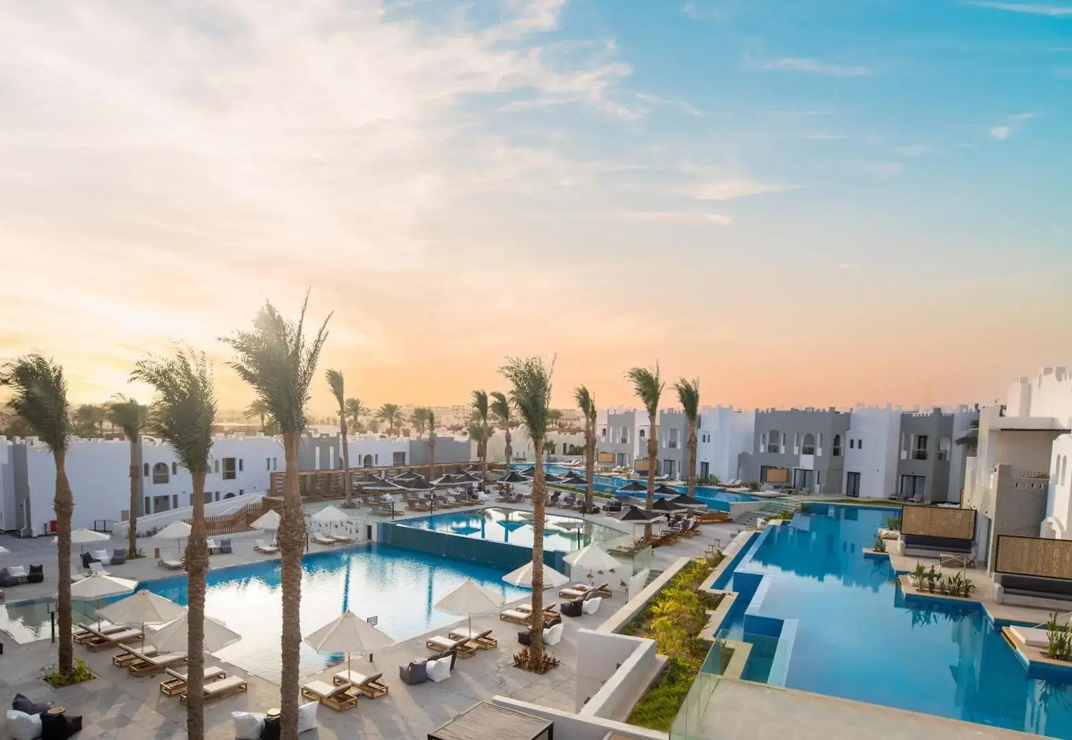 Панорамна гледка към басейните и палмите на комплекса при залез – Sunrise Tucana Resort - Grand Select, Макади Бей